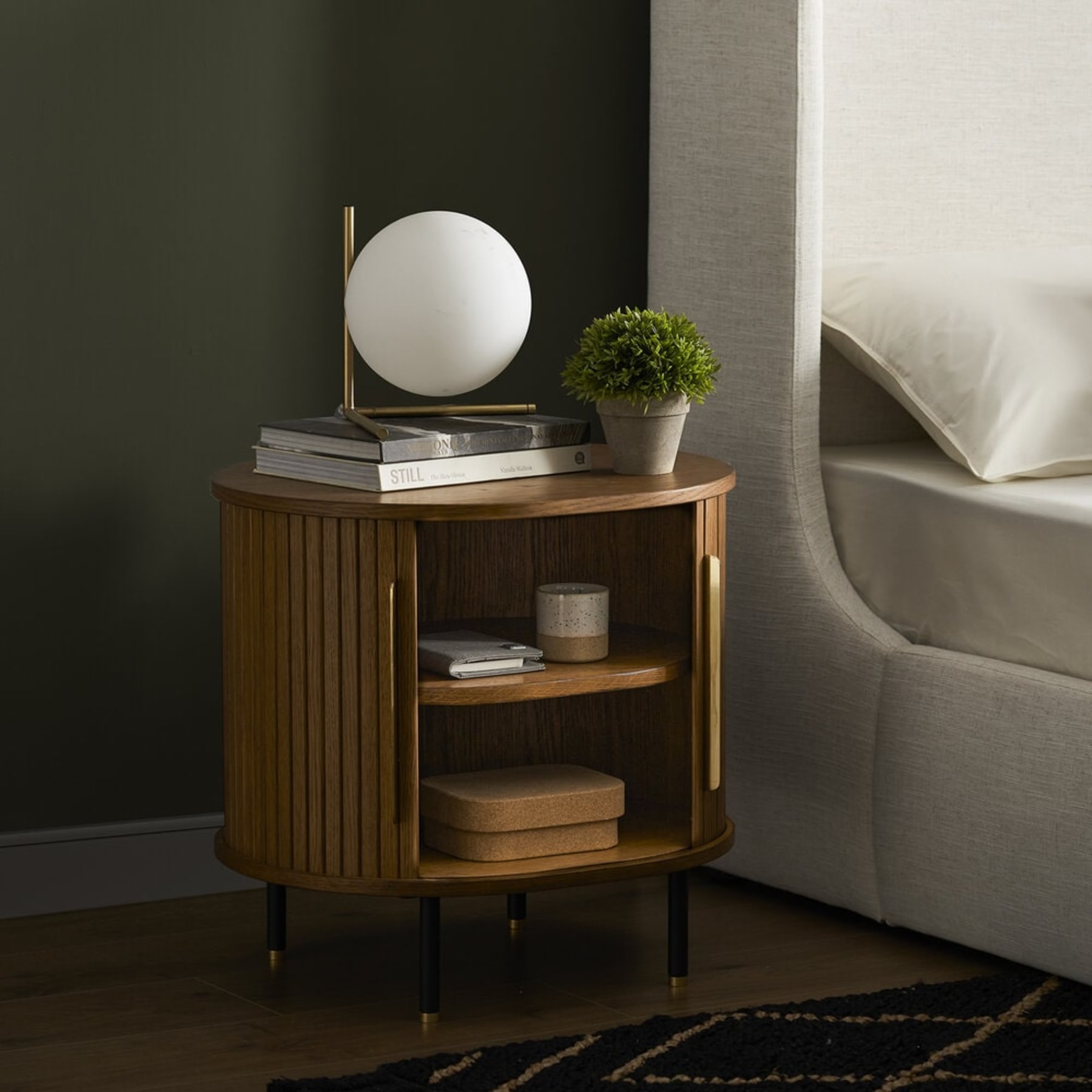 A wooden side table with its doors open has two compartments to store items.