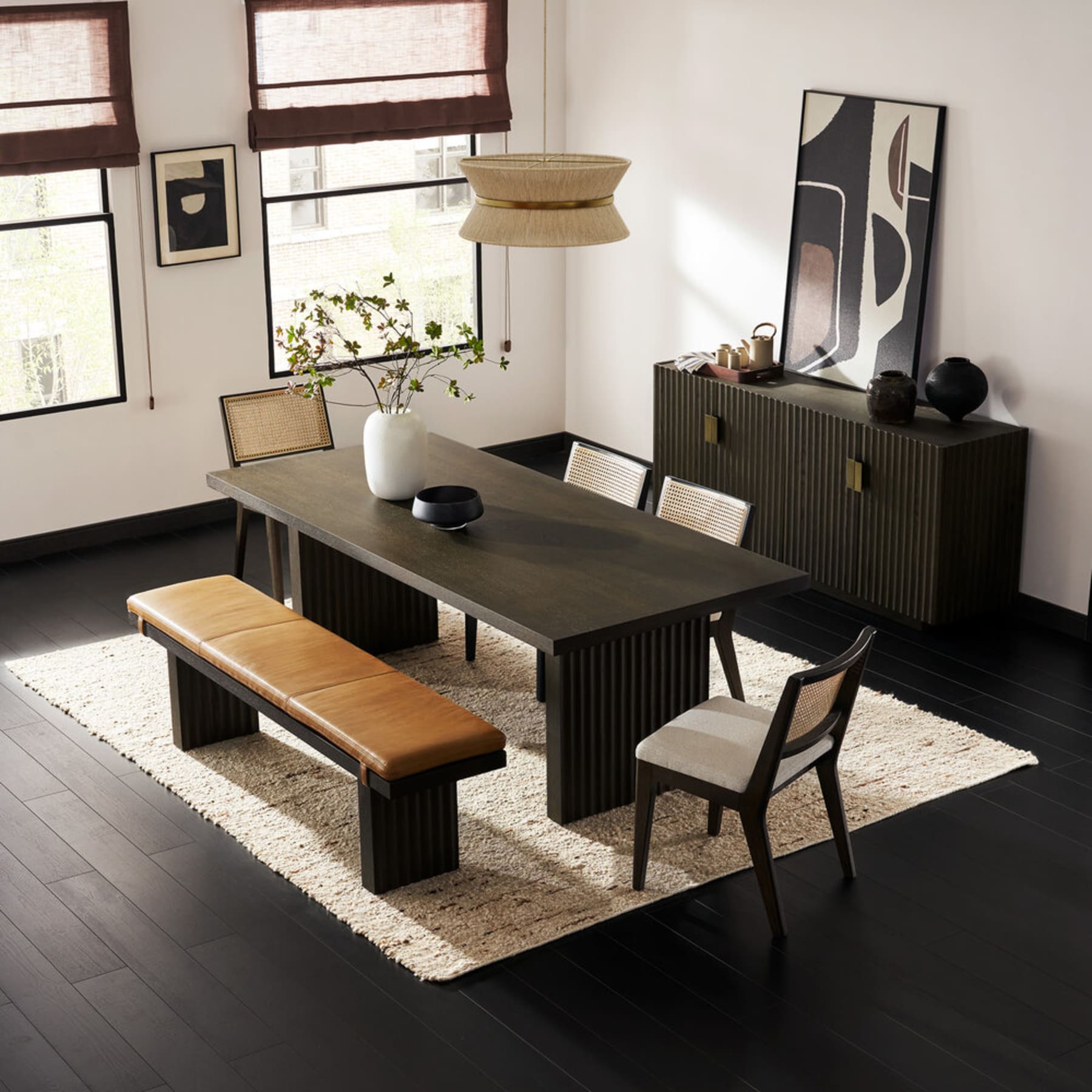 A black dining table with matching chairs and a bench.