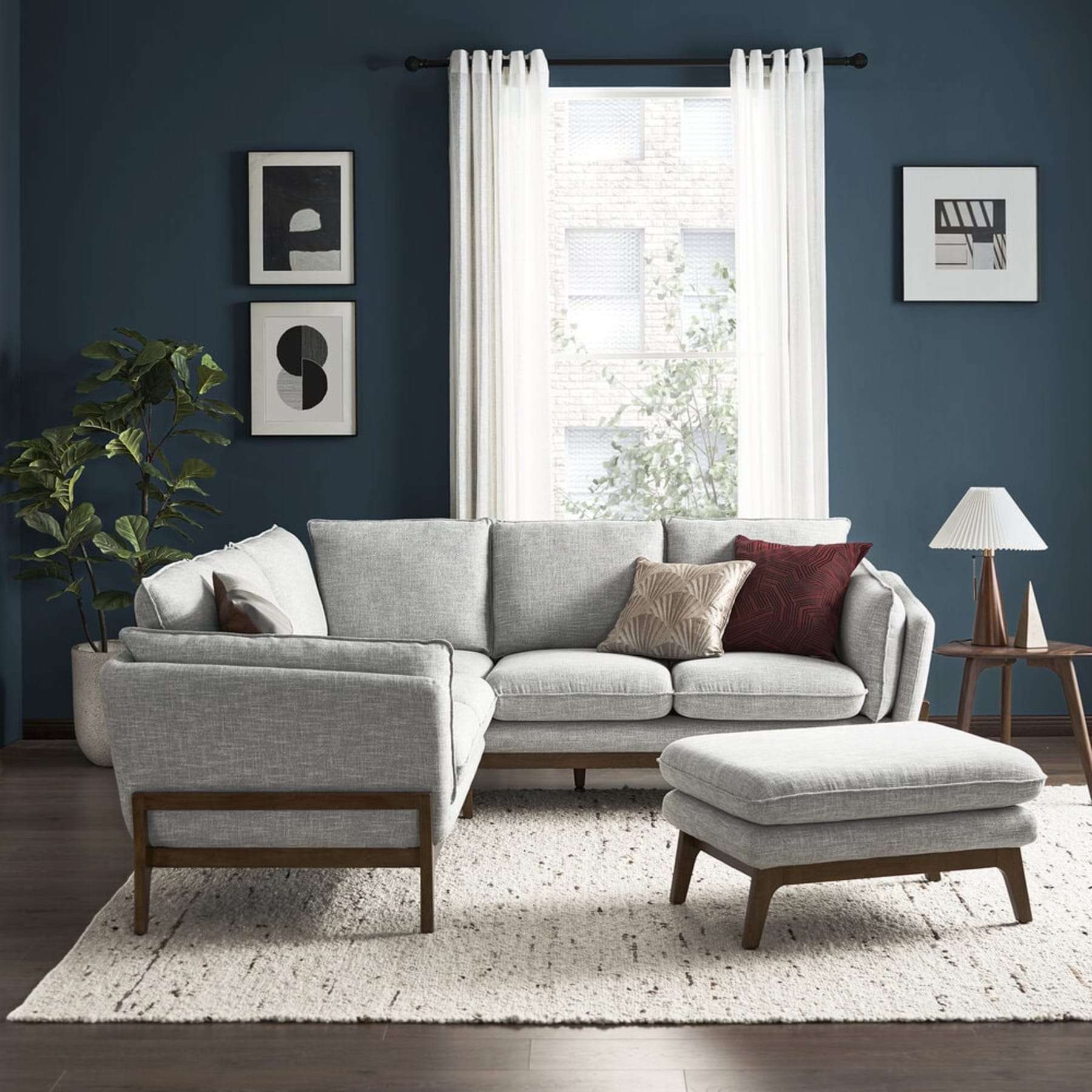 A brown leather sofa and a matching leather ottoman sit in the living room.