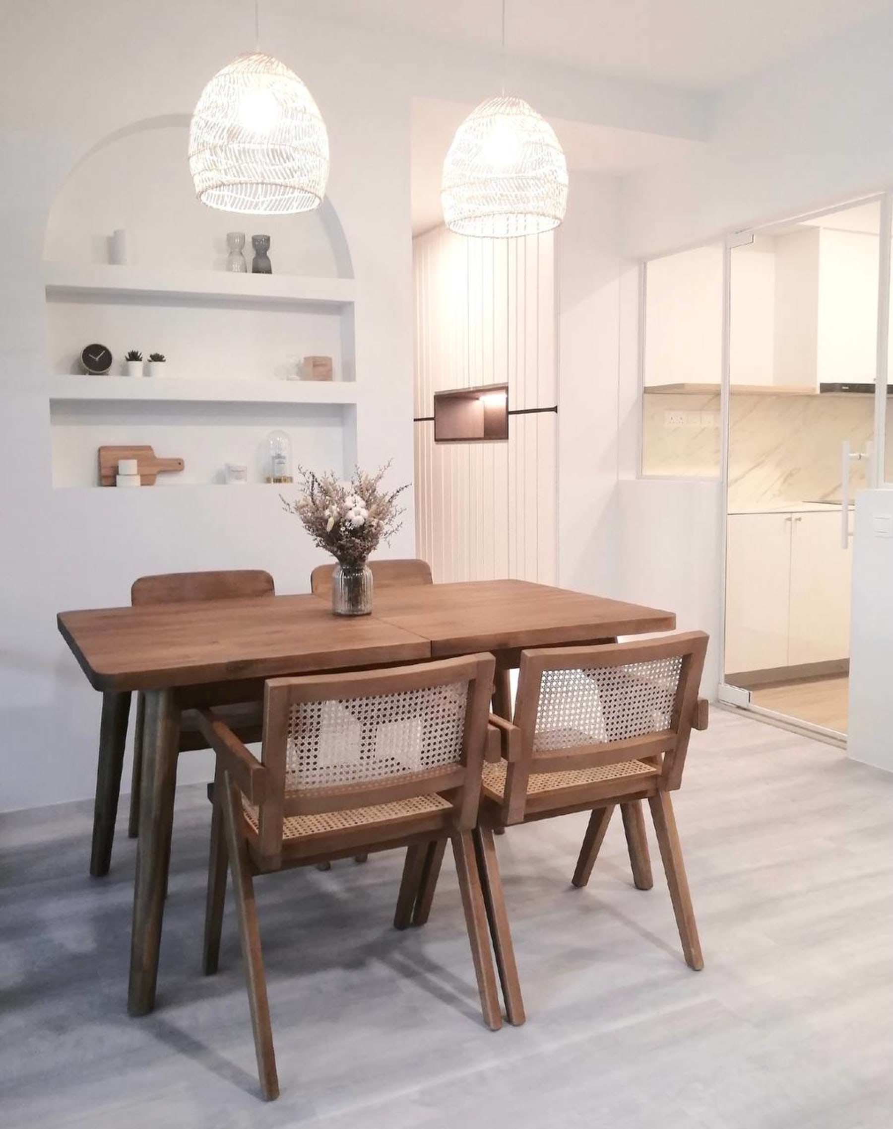 A white glass table top with a conical wooden base and fabric upholstered chairs.