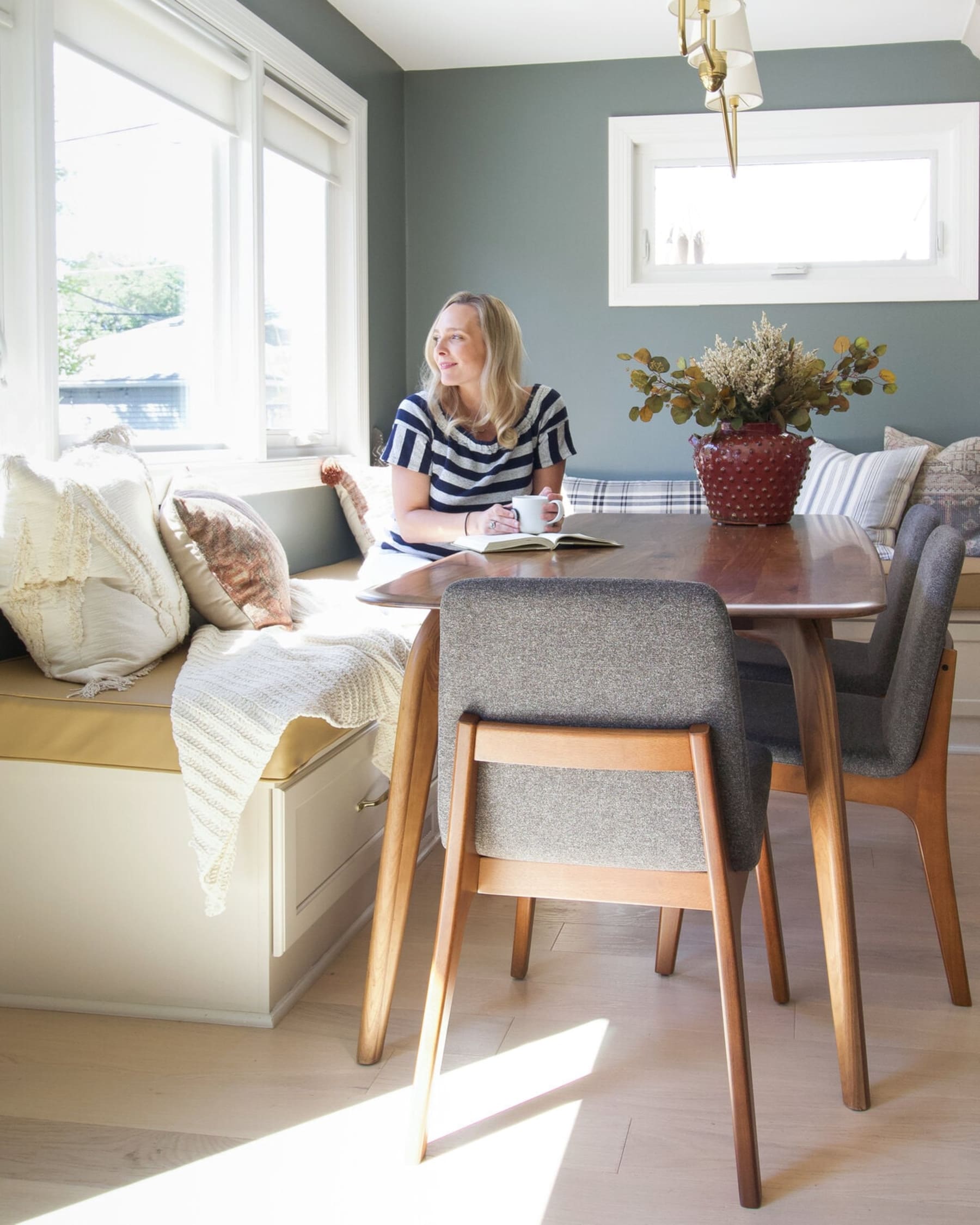 A person at her dining table reading a book.