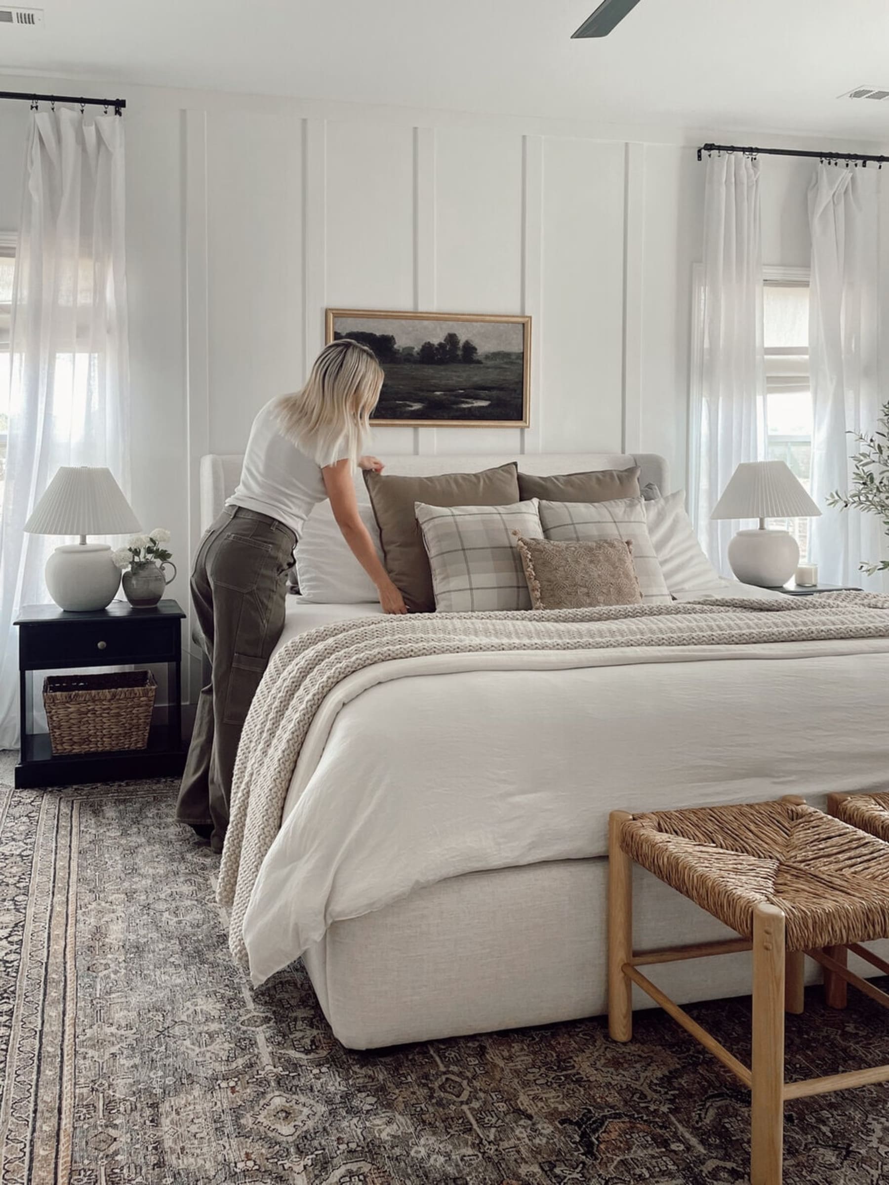 A person assembling the cushions on their bed.