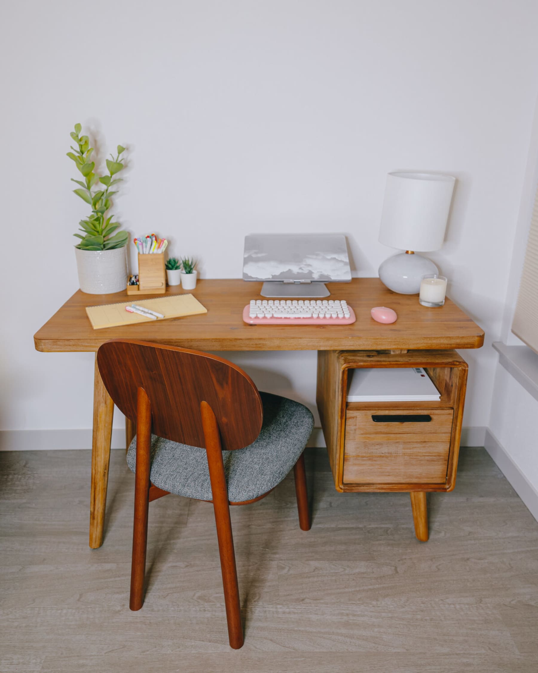 A wooden desk used as a workspace with a wooden chair.