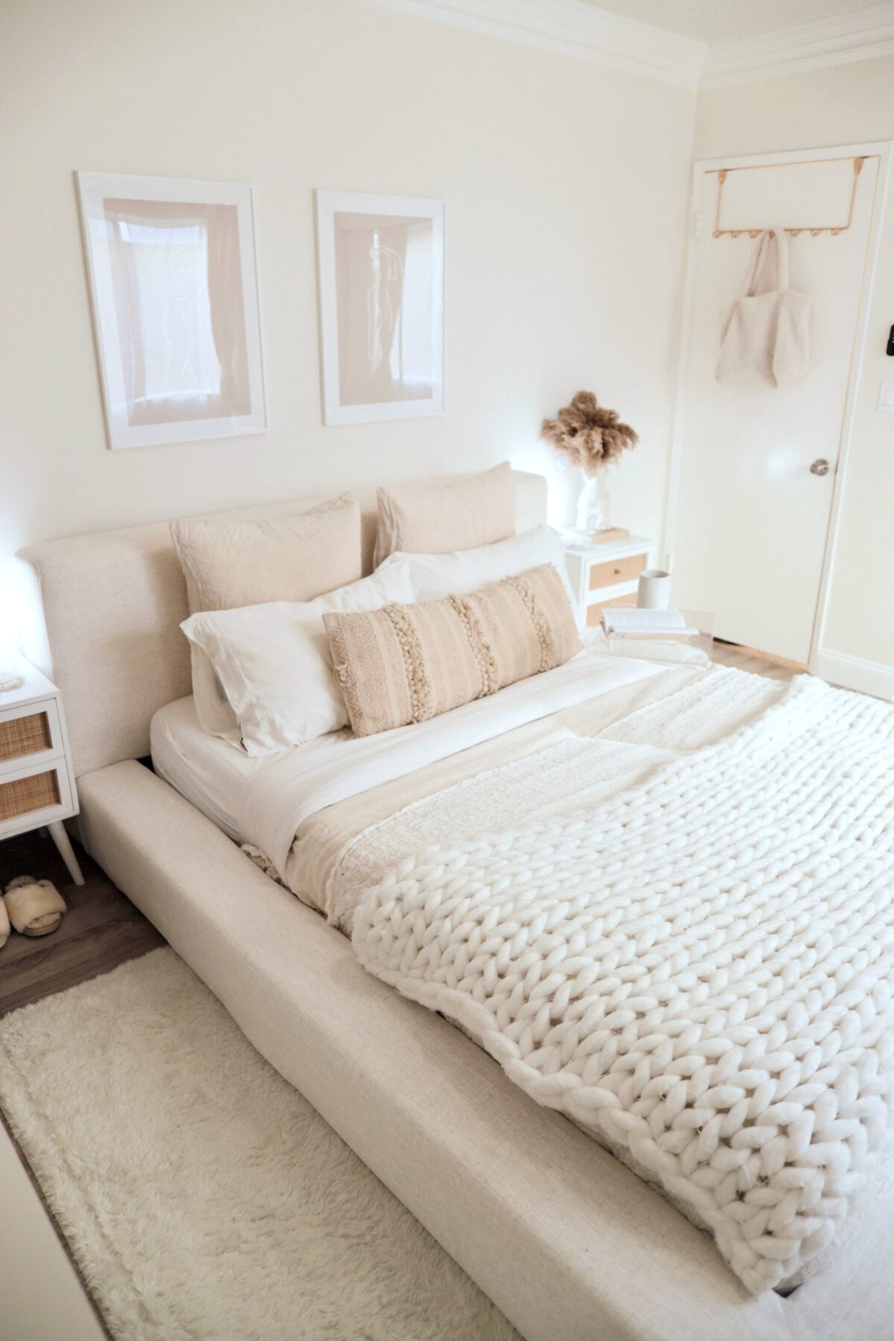 A platform bed with built-in storage with bedding in the drawers.