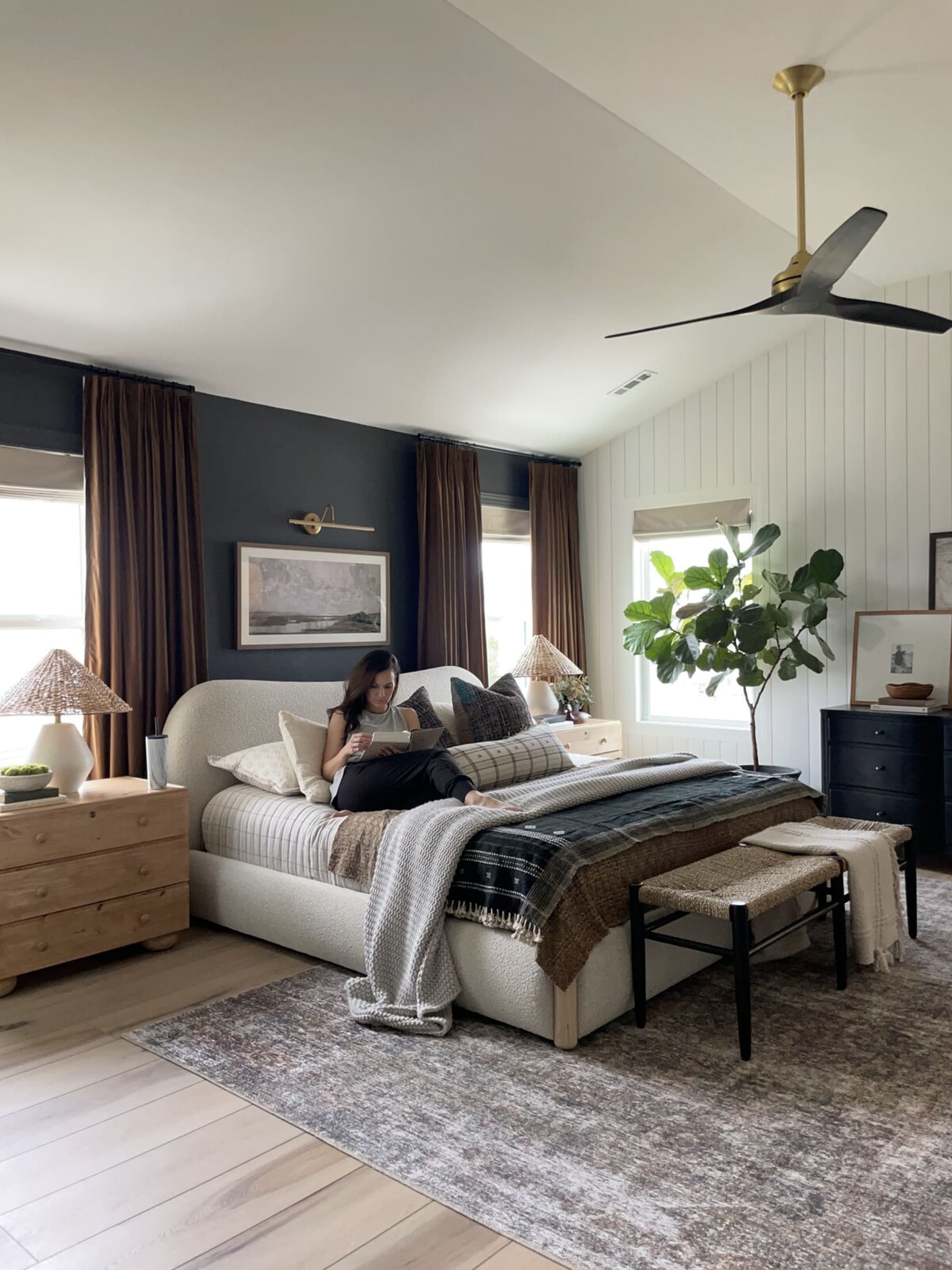 A person is reading a book on a performance fabric upholstered bed.