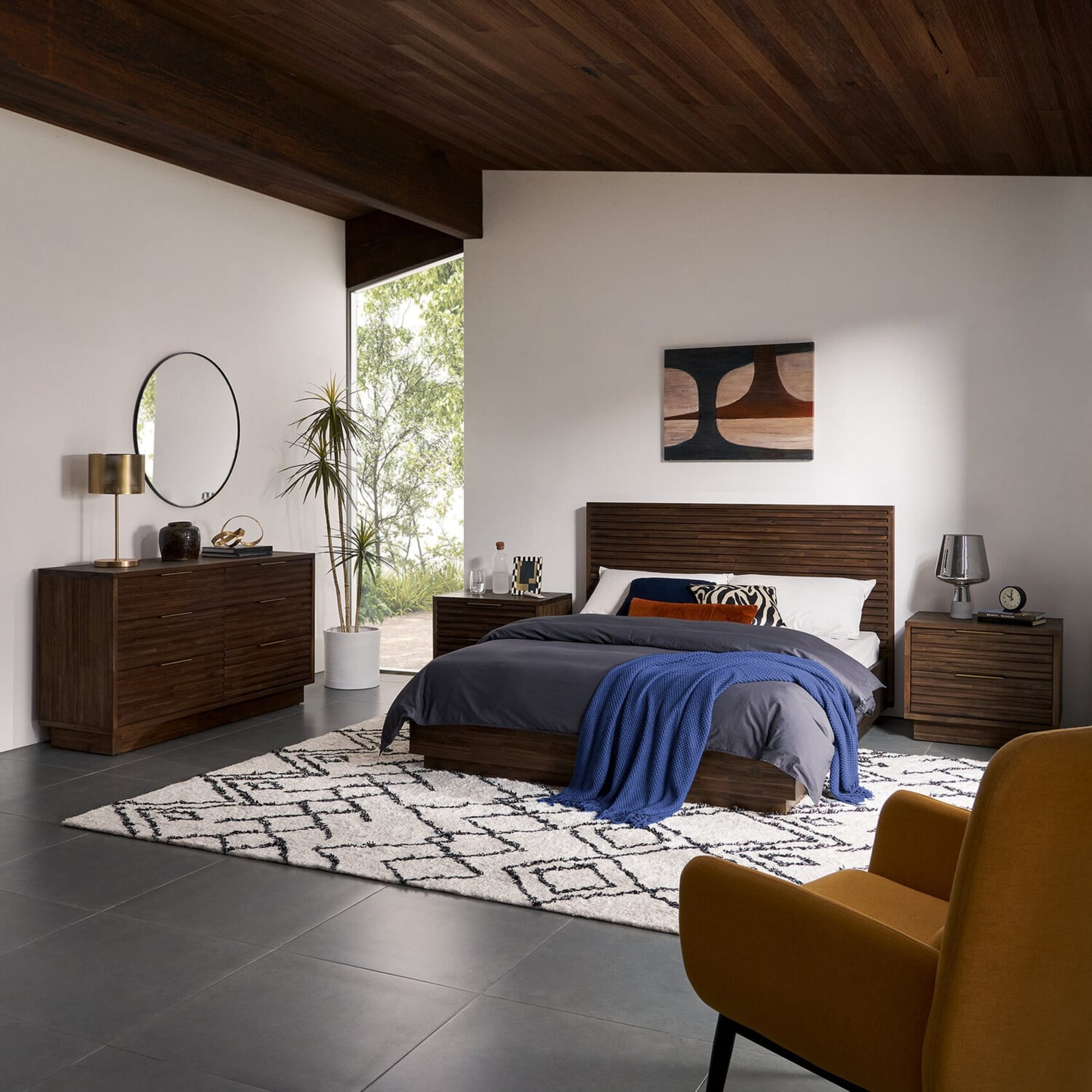 A bedroom set with a dark walnut wood finish features a bed frame, dresser, and nightstands