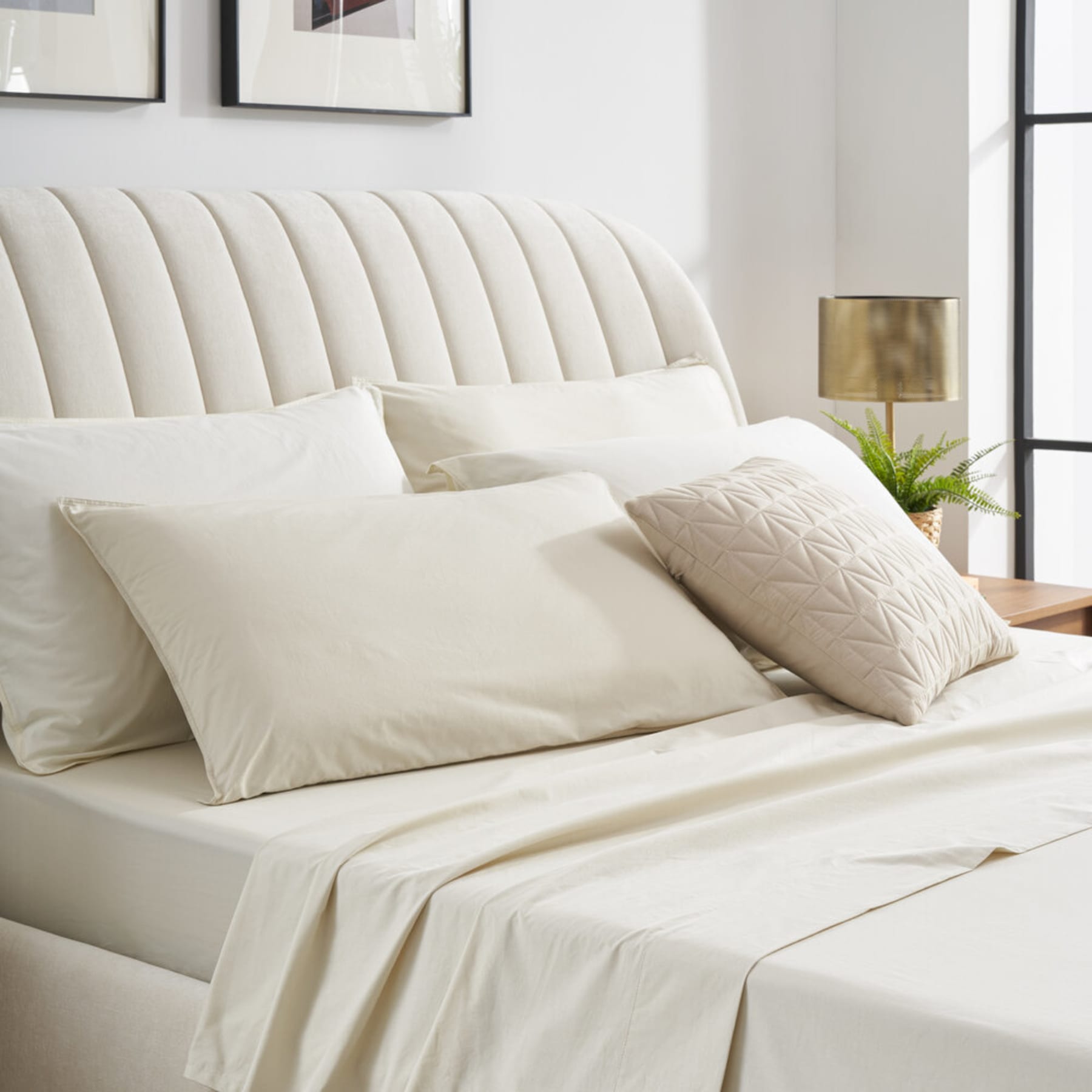 A percale bedding set in a neutral colour with 4 pillows and a cushion.