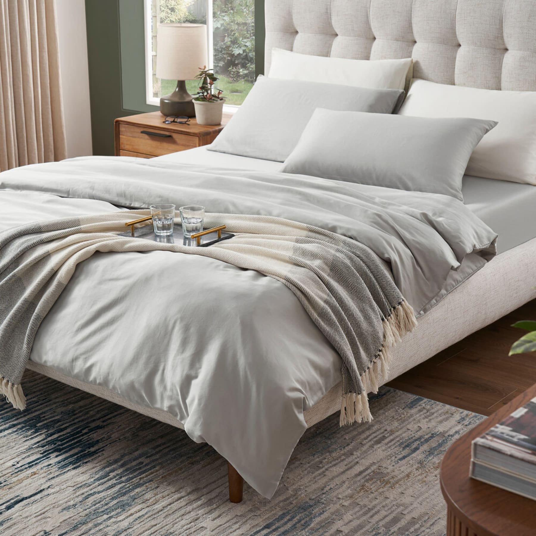 A sateen duvet and bed sheet set in a gray color.