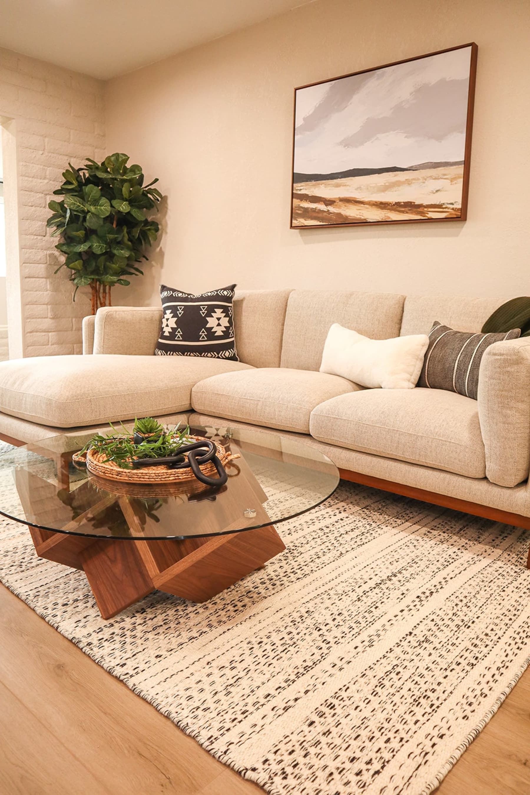 A coffee table with a glass tabletop and abstract base.