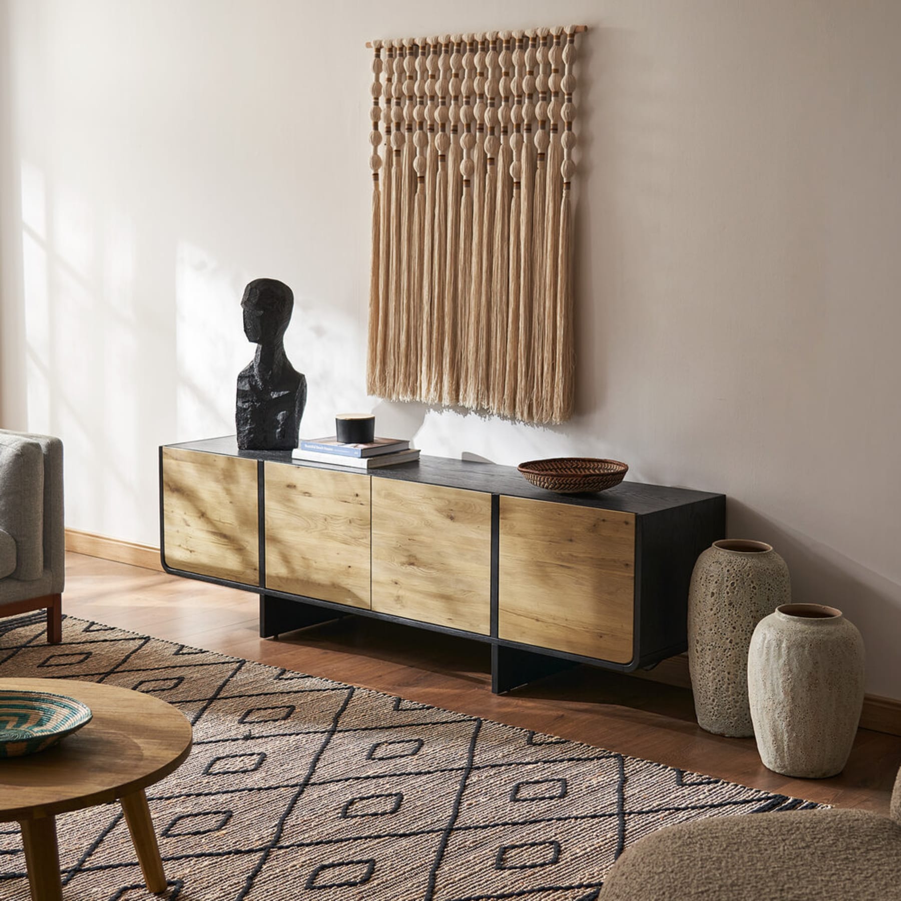 A black TV stand with oak veneer doors.