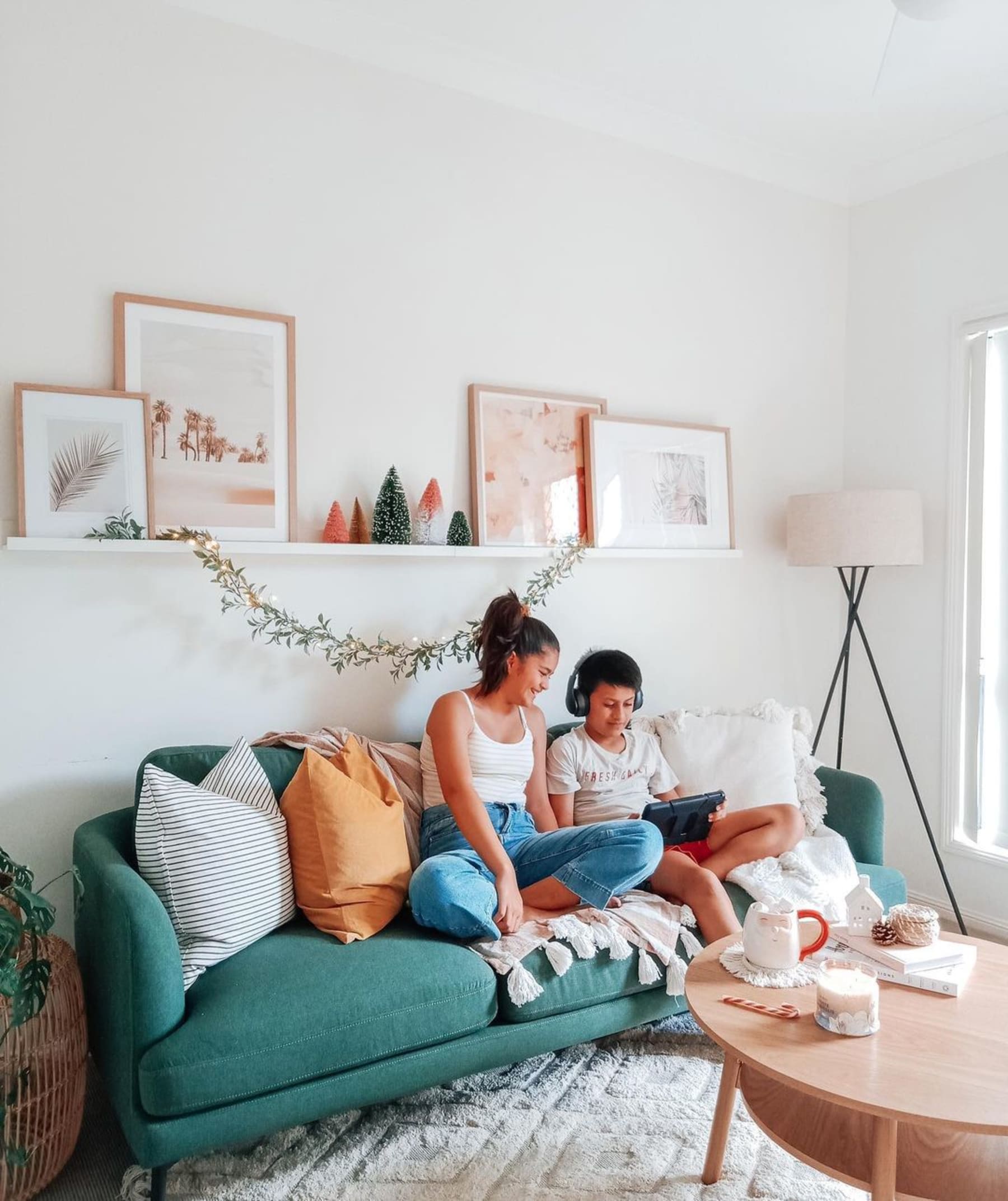 A blue fabric sofa with 2 people sitting on it.