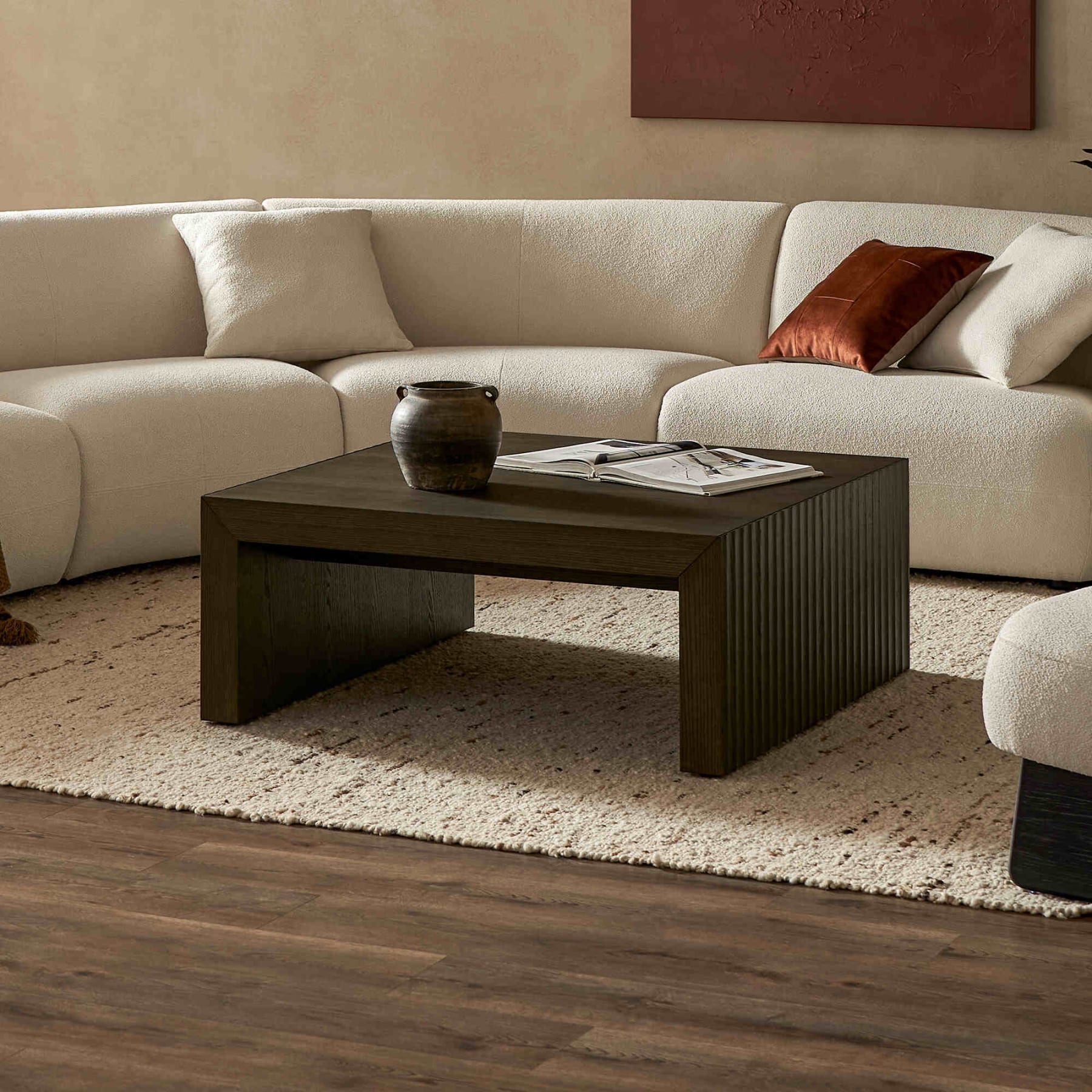 Square fluted dark wooden coffee table on a jute area rug