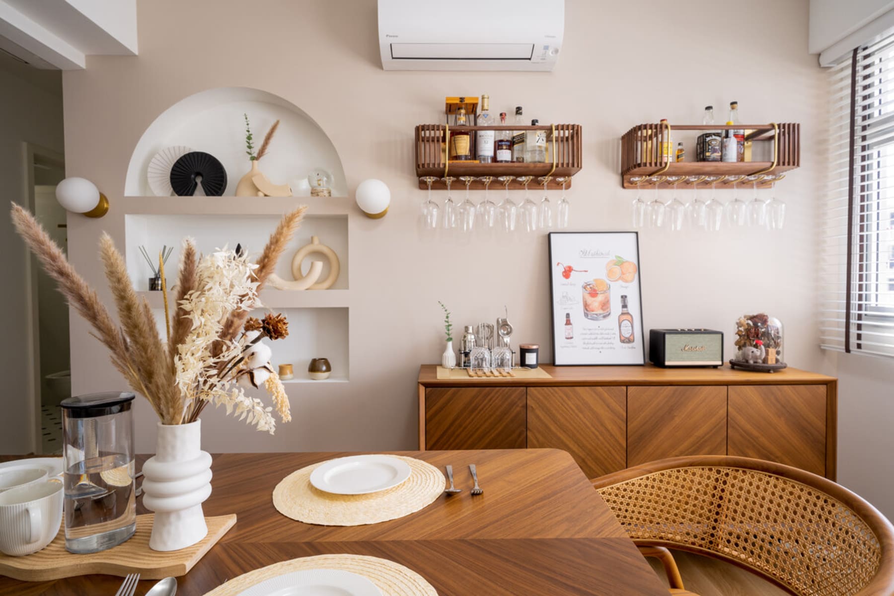 A wooden sideboard with chevron patterns and wine glasses hanging above.