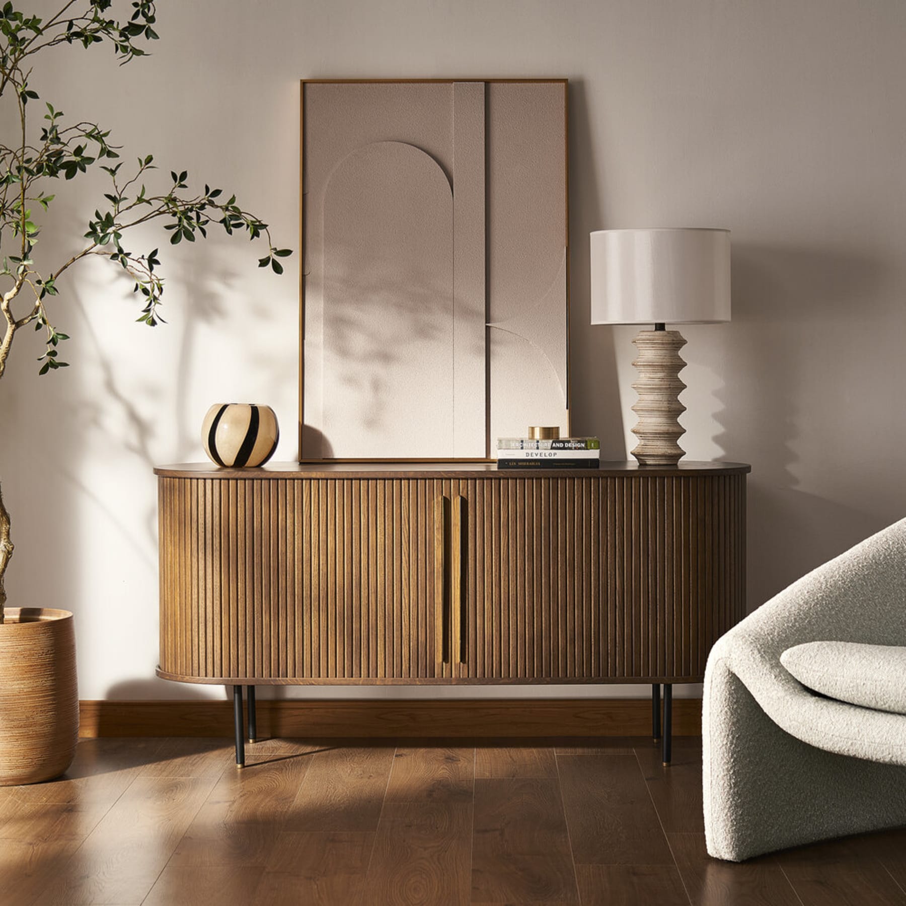 A wooden sideboard with tamboured doors and an oval silhouette.