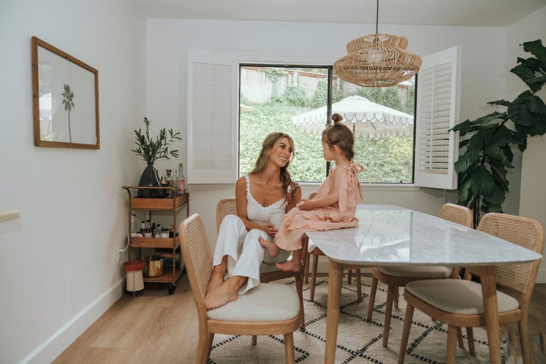 A person sitting at the dining table with their child on the marble tabletop.