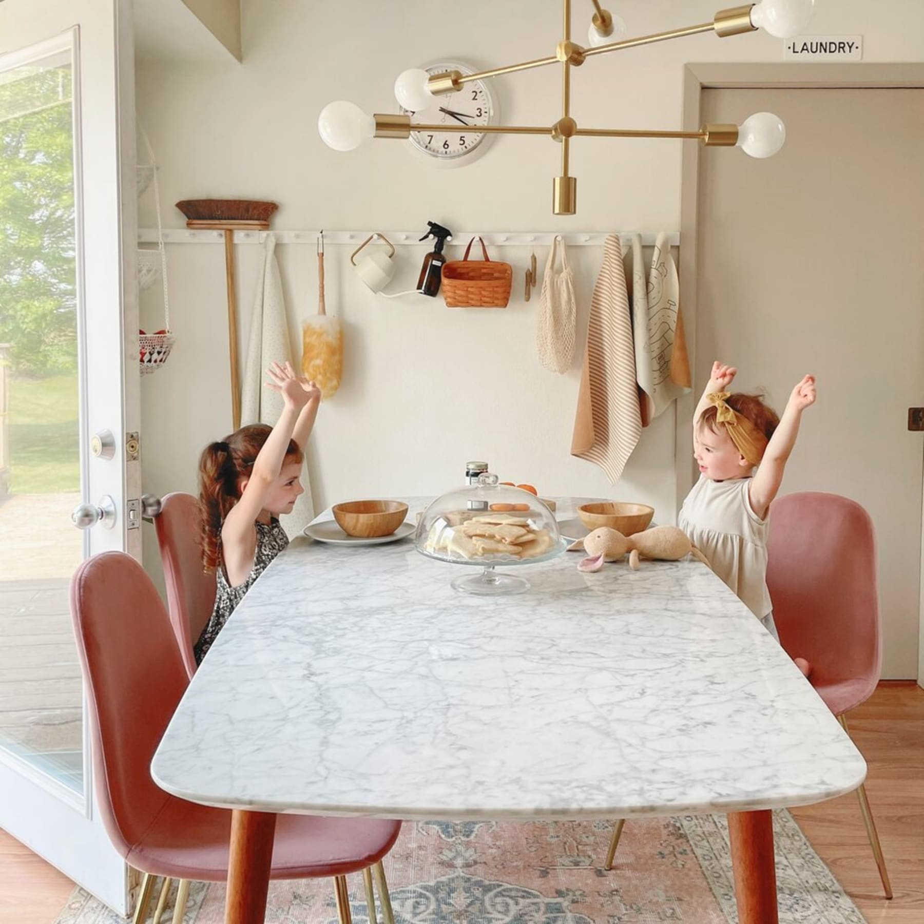 A marble dining table with 4 dining chairs with woven seats.