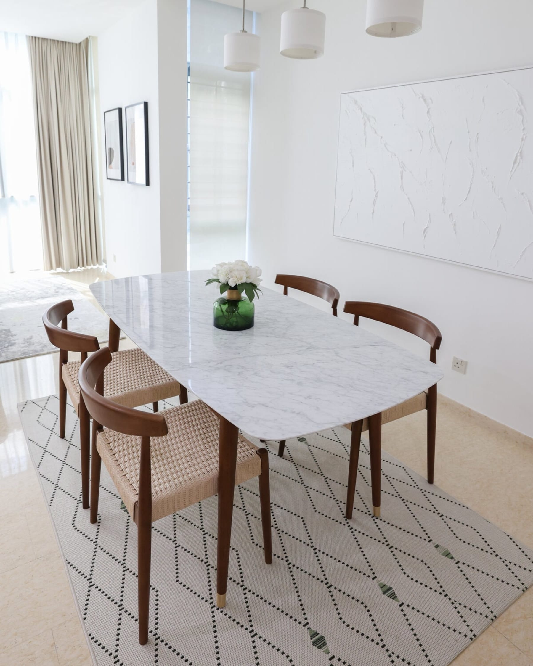 A marble dining table with 4 dining chairs with woven seats.