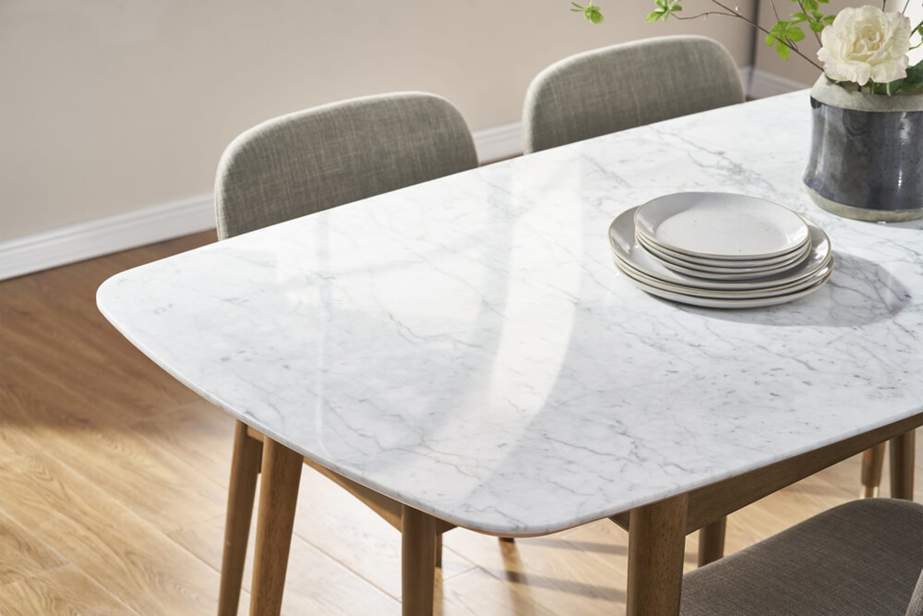 A marble dining table with a few plates stacked on top.