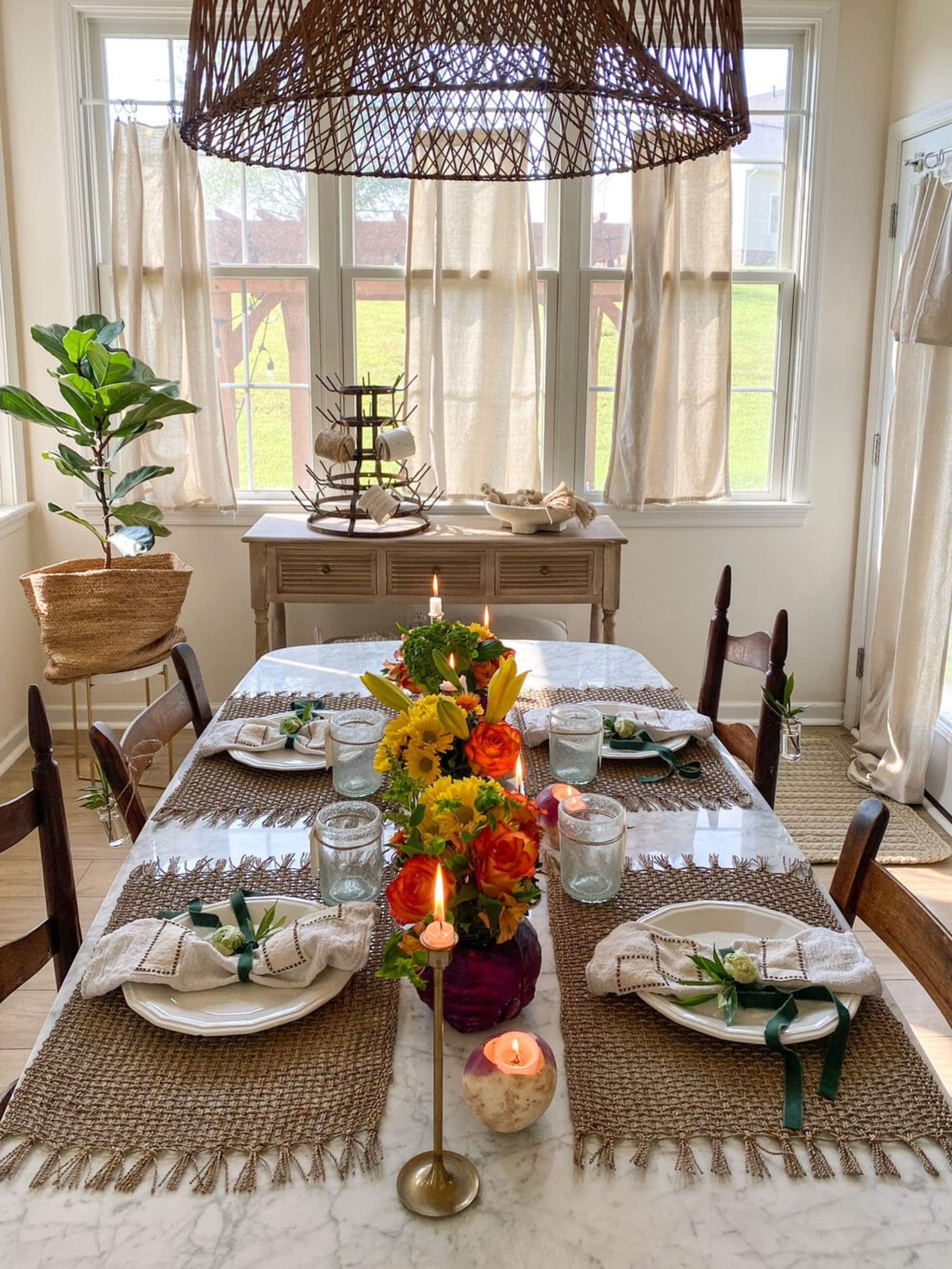 4 sets of cutlery and plates with table decorations are placed neatly on a marble dining table.