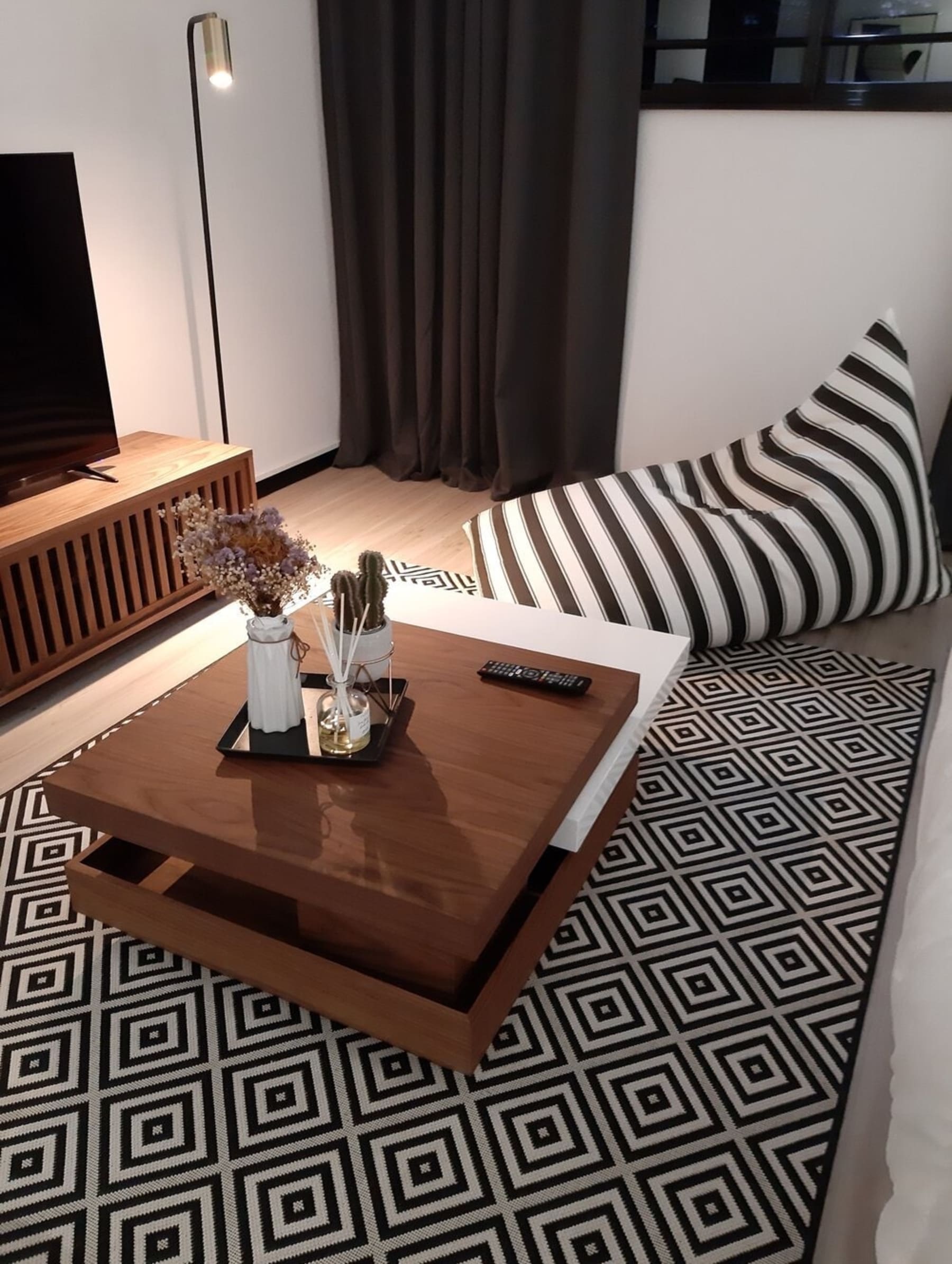 A rotatable coffee table with a black tray, potted plants, and a diffuser.