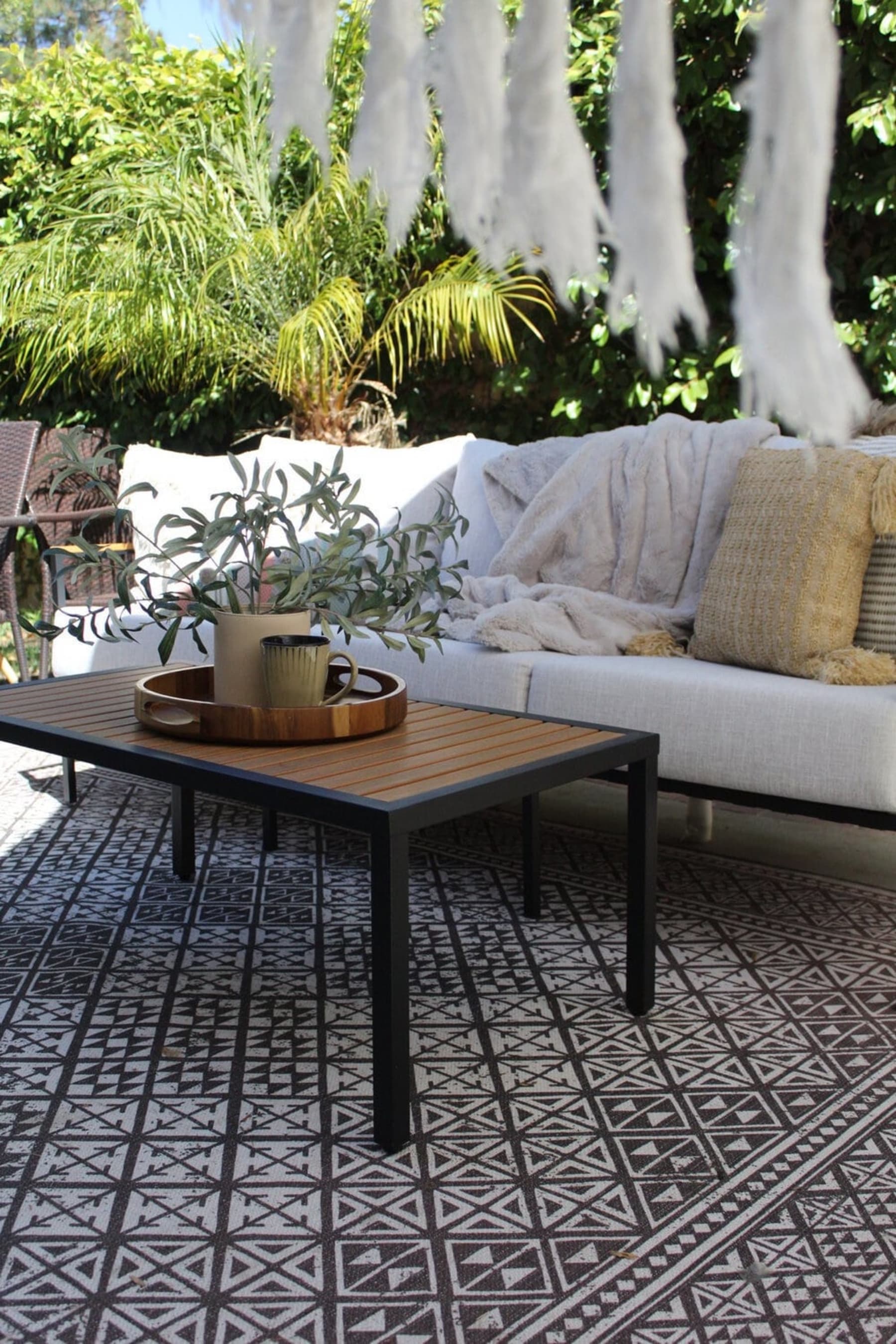 Glass containers holding matchsticks and candles are placed on a white coffee table tray.