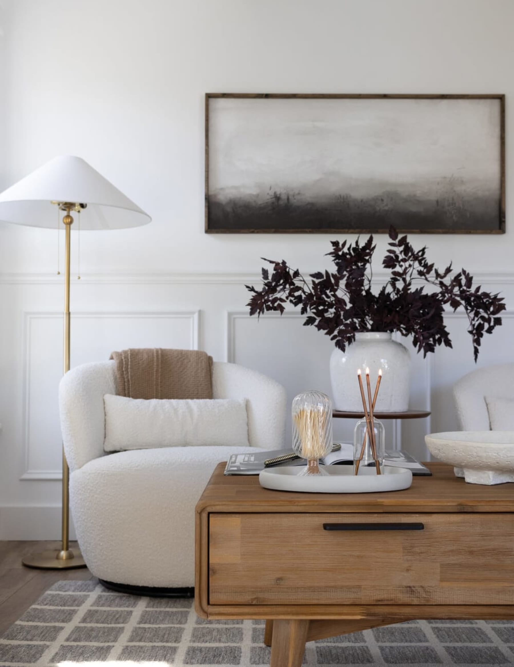 Glass containers holding matchsticks and candles are placed on a white coffee table tray.