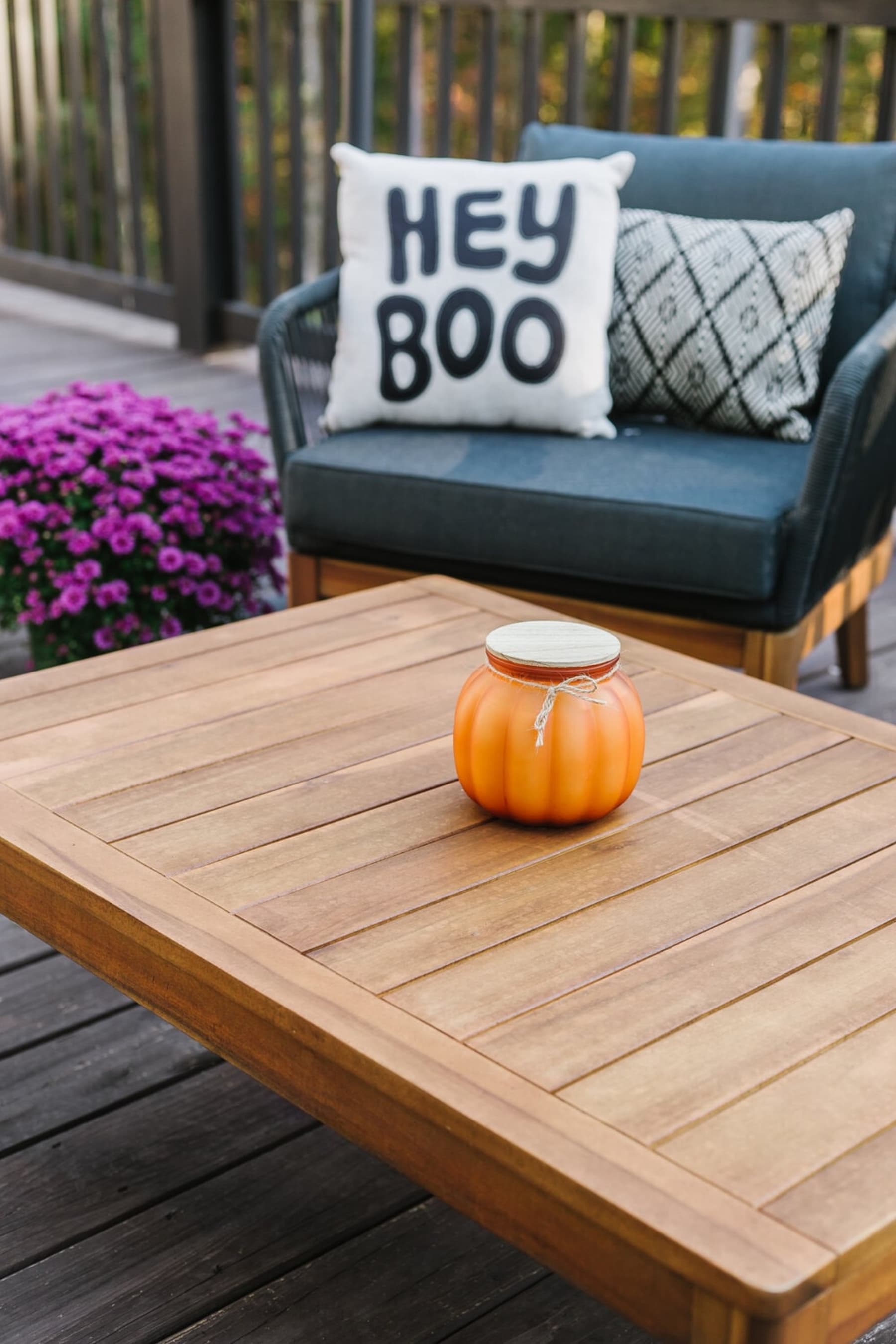 A close-up shot of a wooden coffee table with a decorative pumpkin.