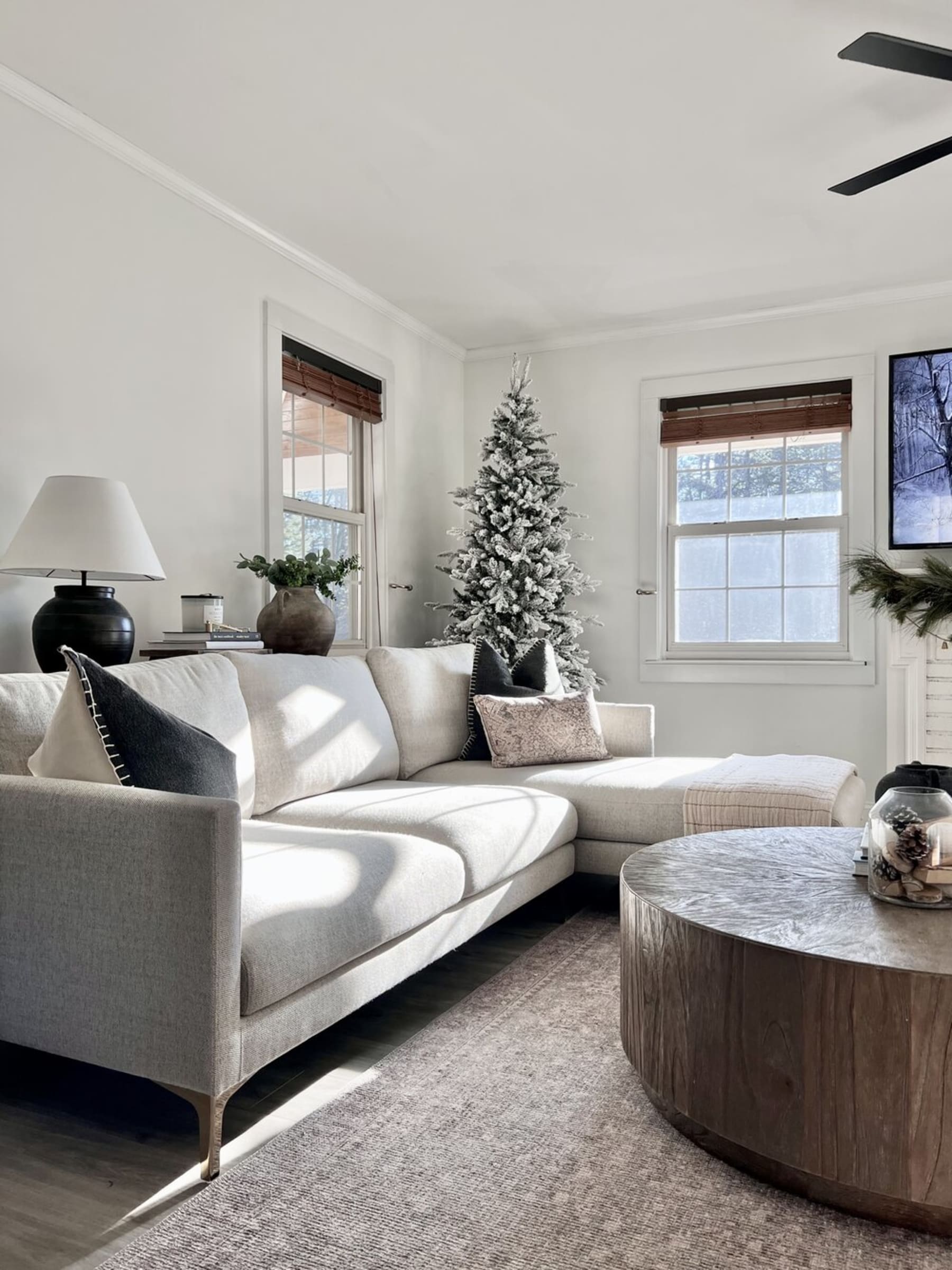 A gray fabric sectional sofa and a wooden round coffee table.