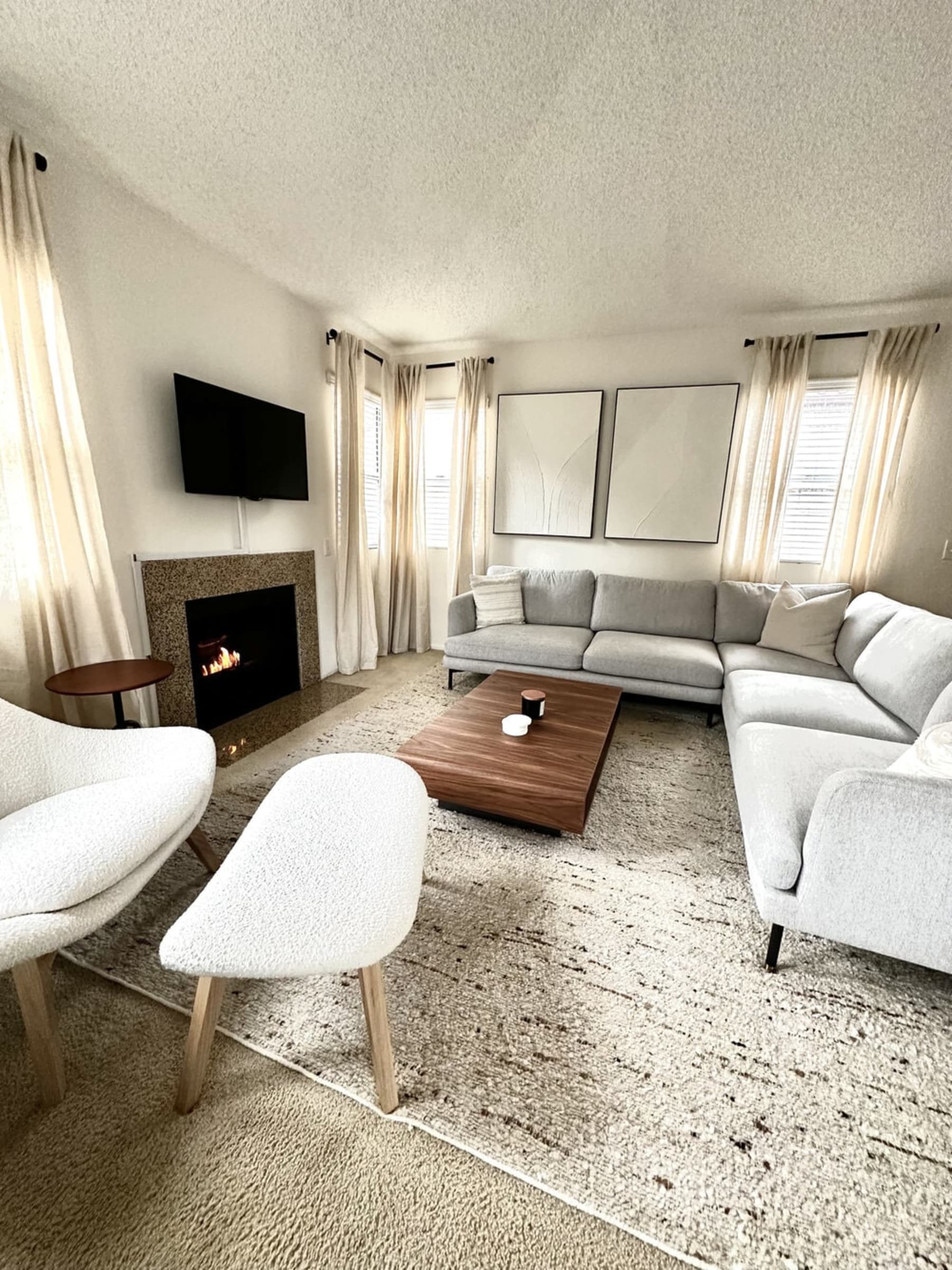 A living room with a sectional sofa, an armchair, and a coffee table anchored by a wool area rug.