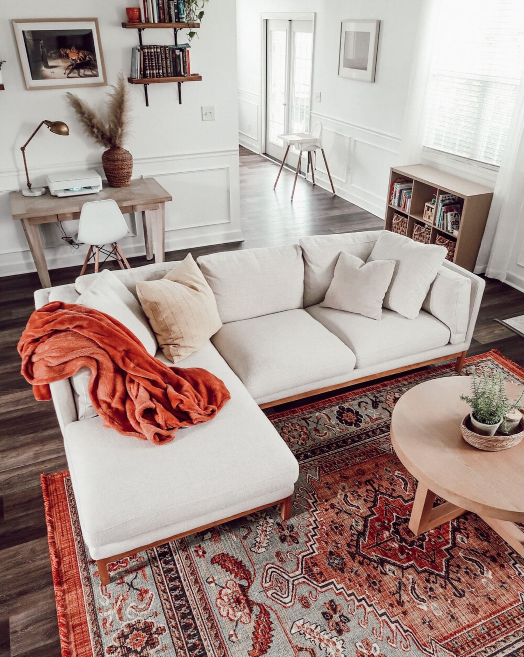 A jute area rug helps to anchor a white sectional sofa and coffee table.