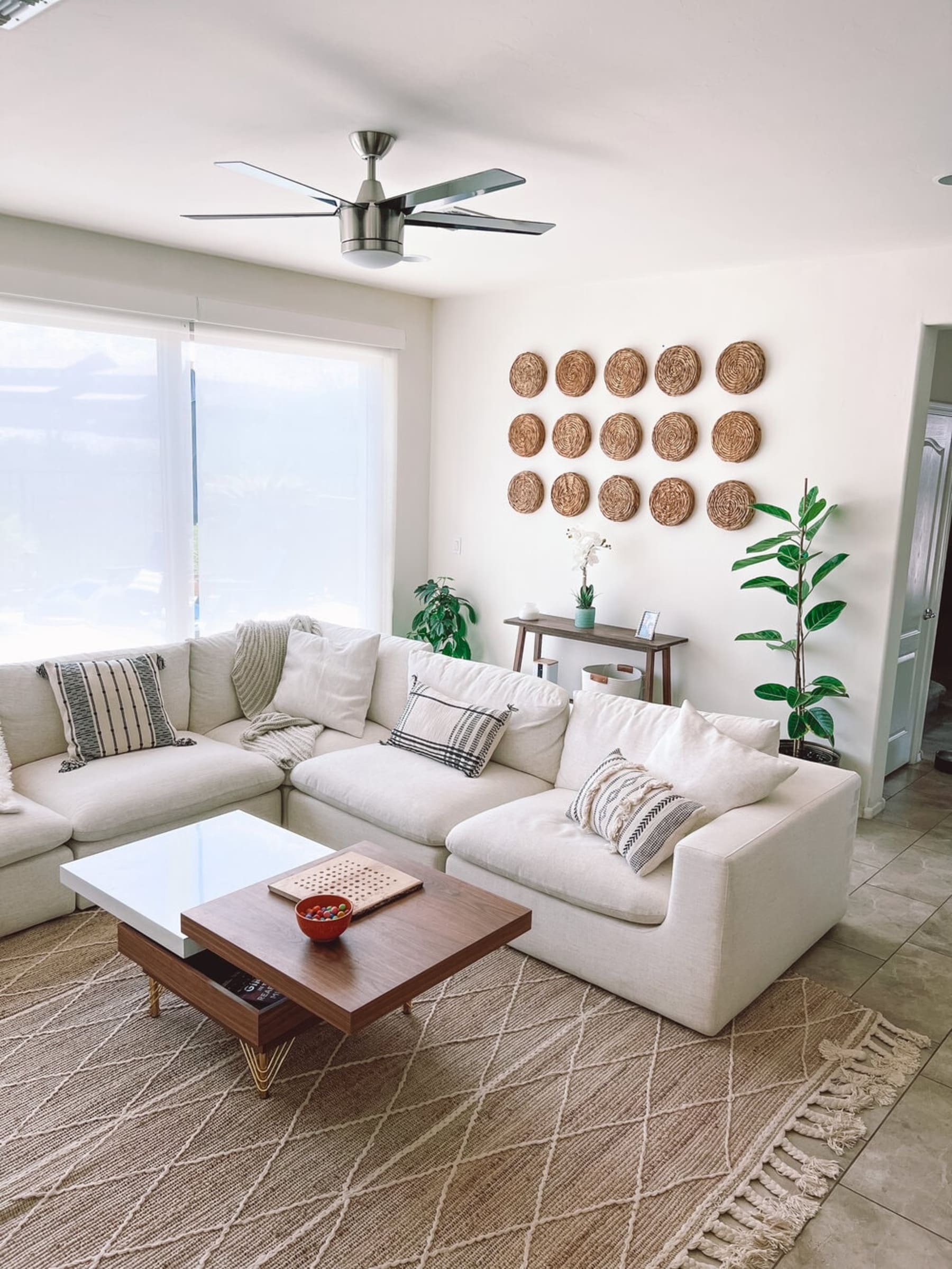 A sectional sofa with different colored and patterned cushions and throws.