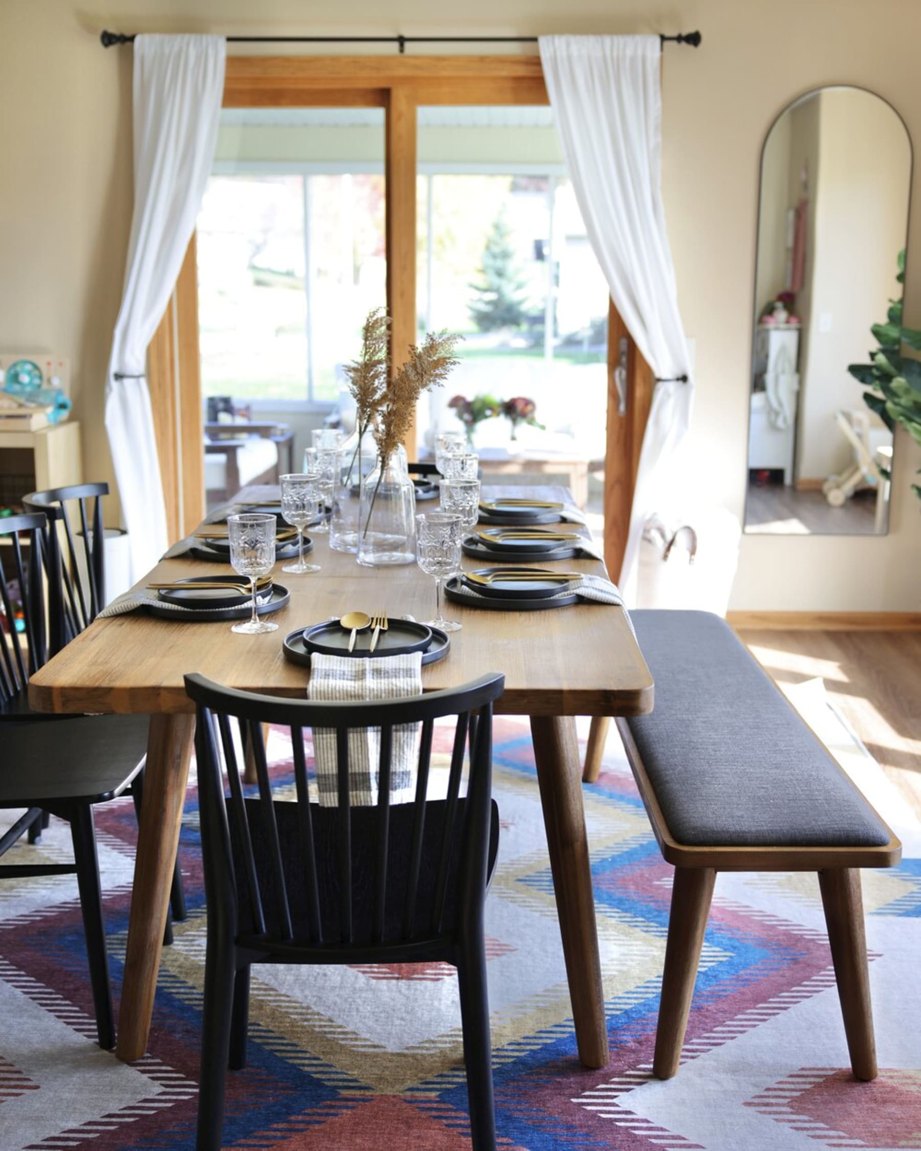 A wooden dining table and matching cushioned bench.