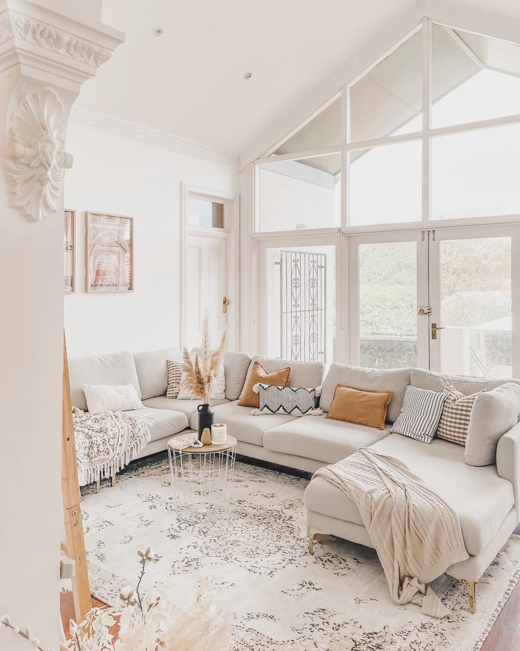 A U-shaped sectional sofa decorated with several cushions and throws.