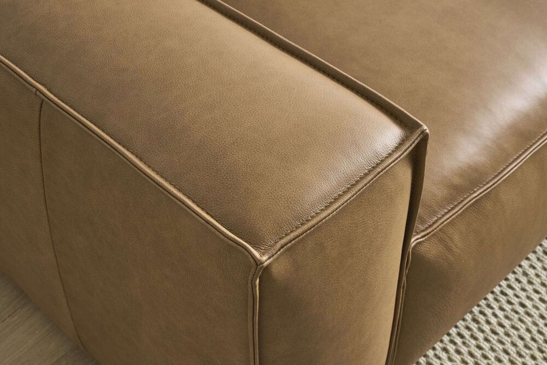 A close up shot of a corner of a leather sofa.