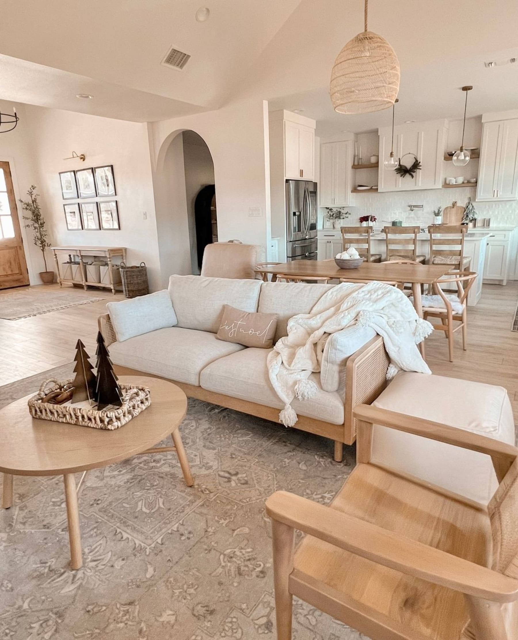 A cane sofa with several wooden furniture in a living room.