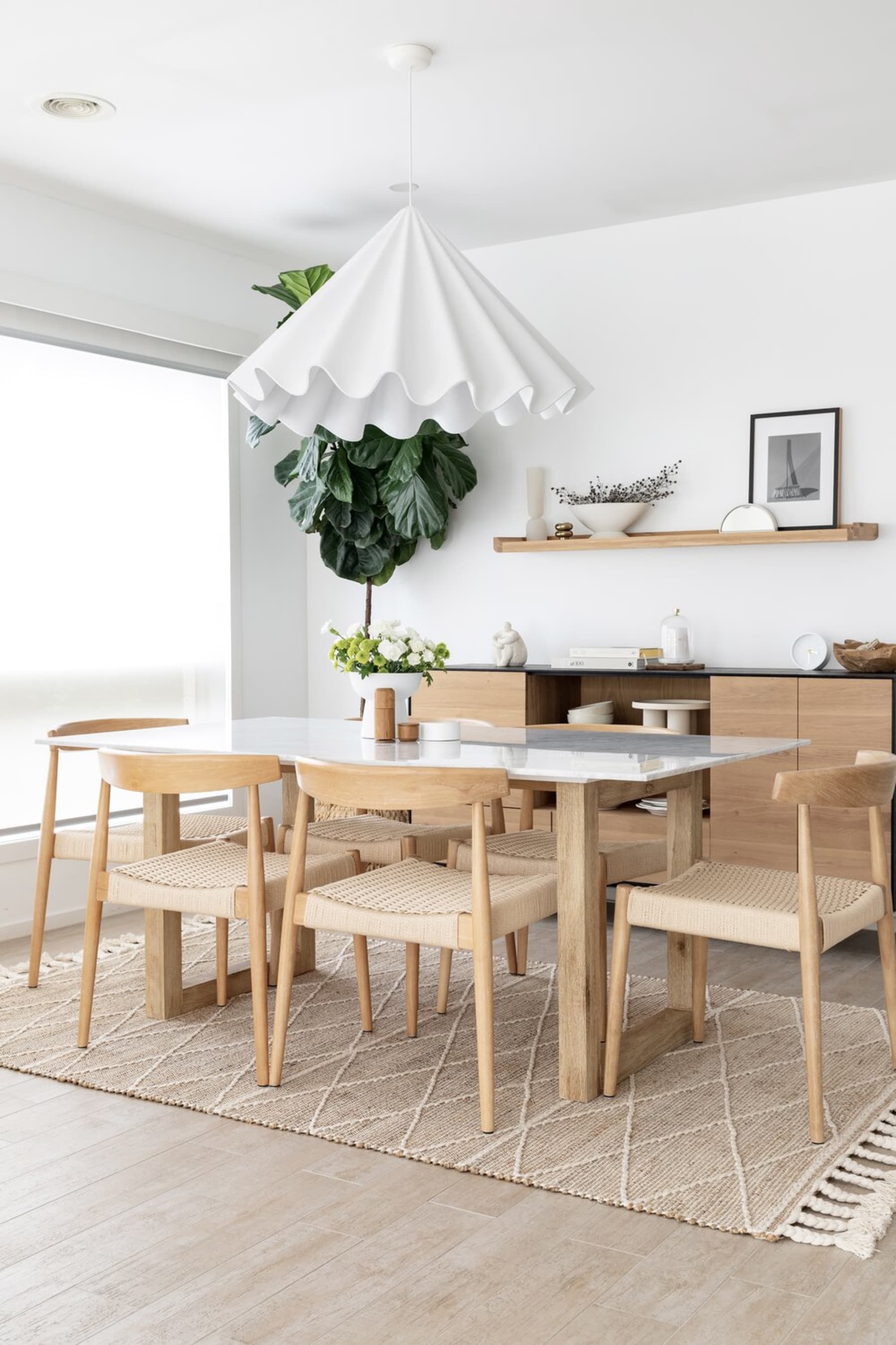 A jute area rug helps to anchor a dining table and 6 dining chairs.