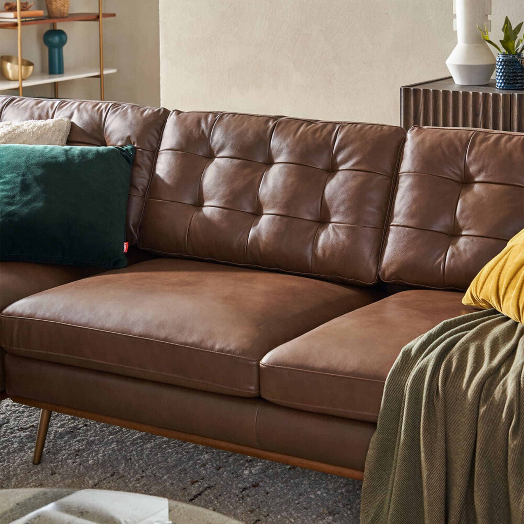 A close up shot of a leather sofa with tufted backrests