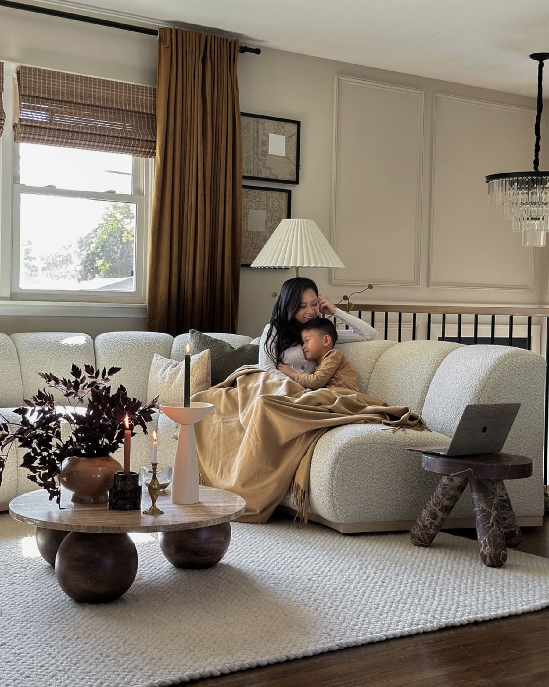 A mother and child sitting on a performance boucle curved sofa.