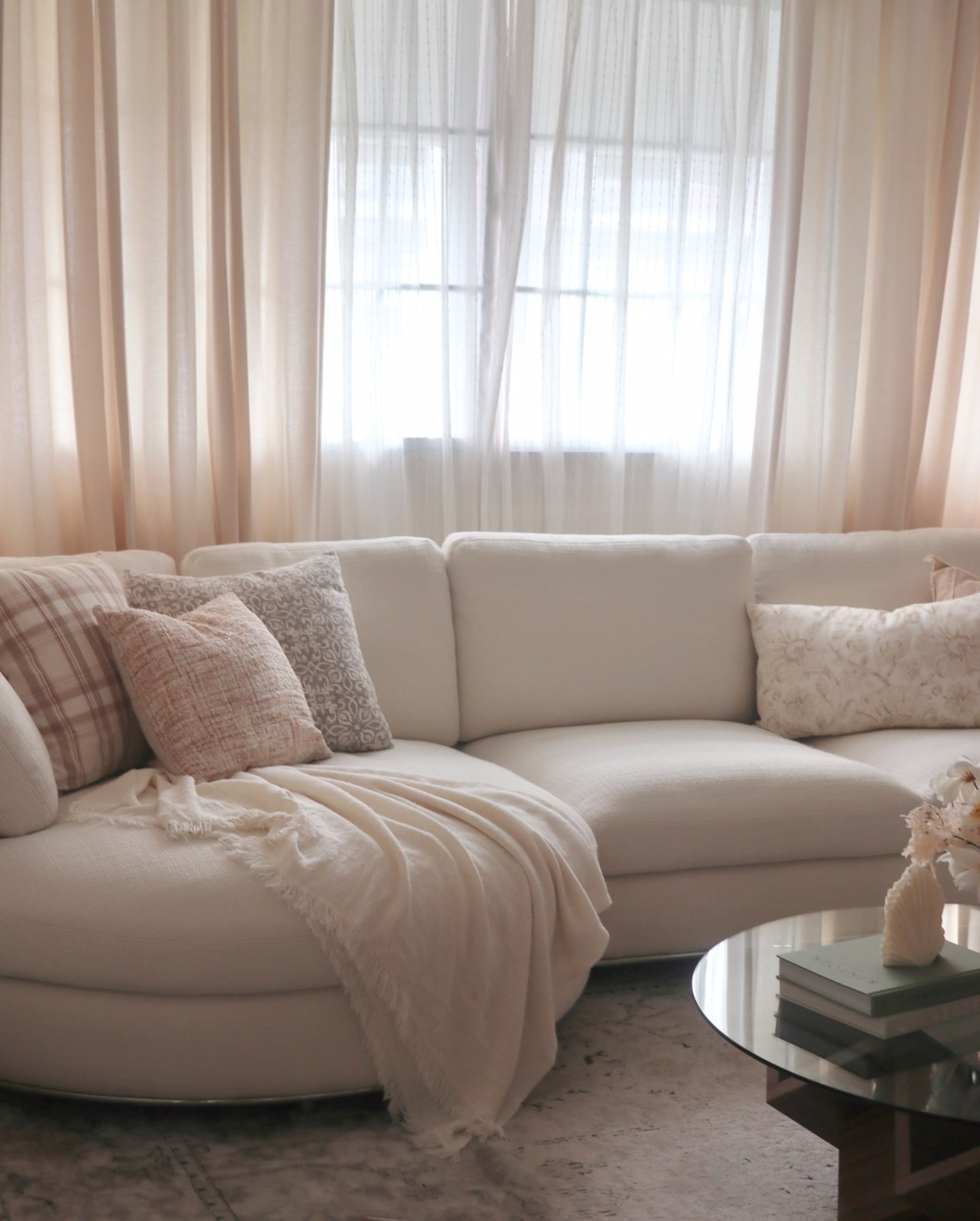 A person lounging with their dog on a gray sectional sofa.