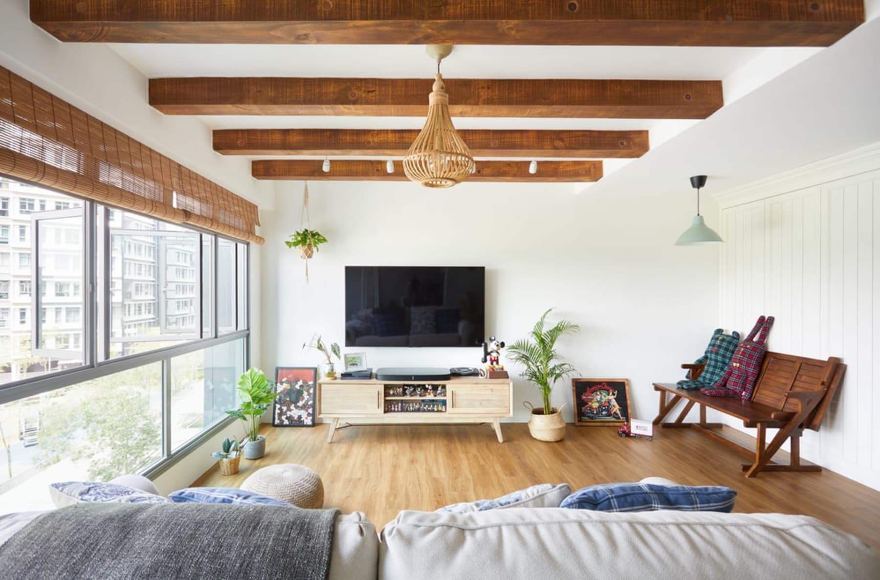 A living room with wooden beams, flooring, and lots of natural light.