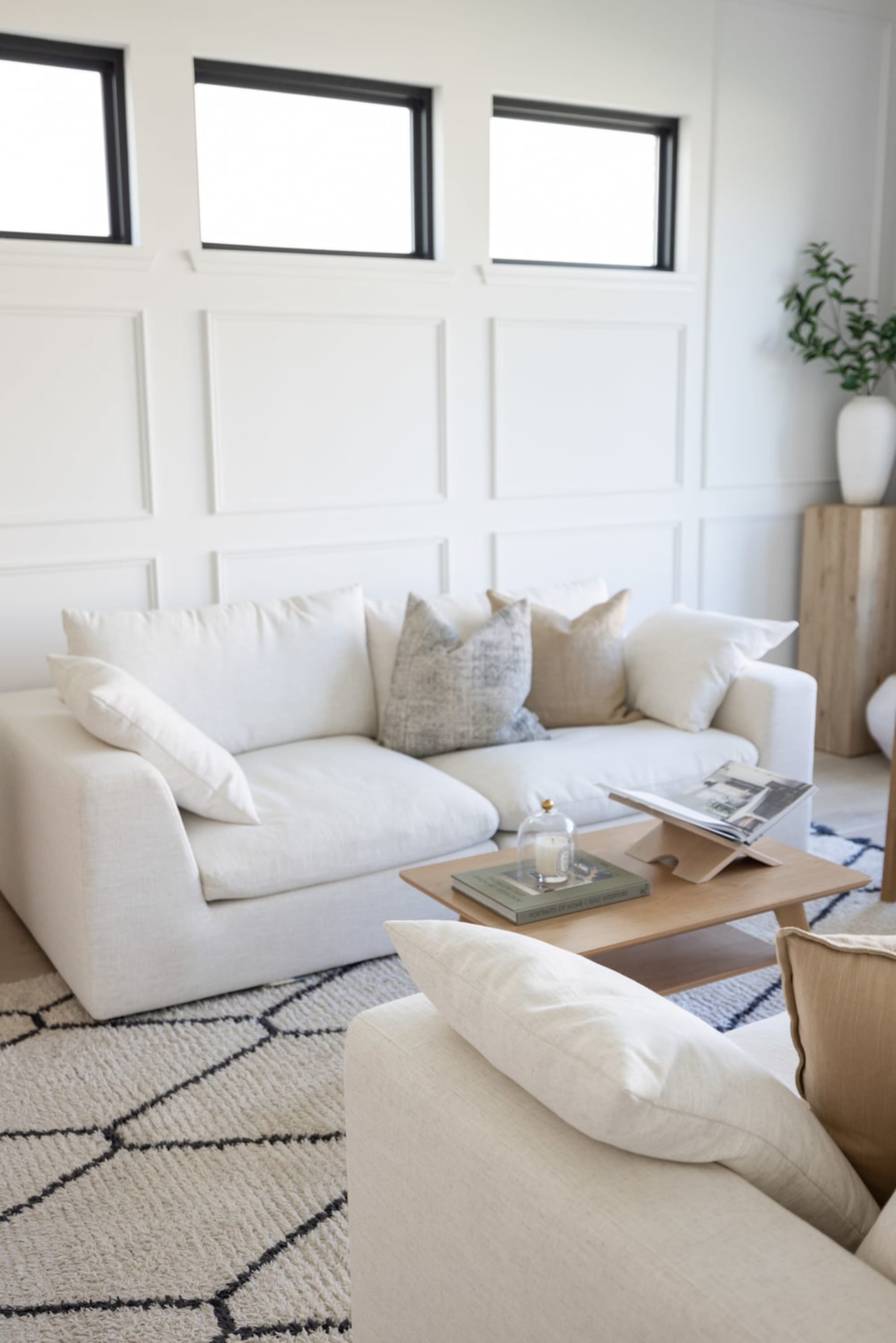 A fabric sofa against a white wall with trimming.