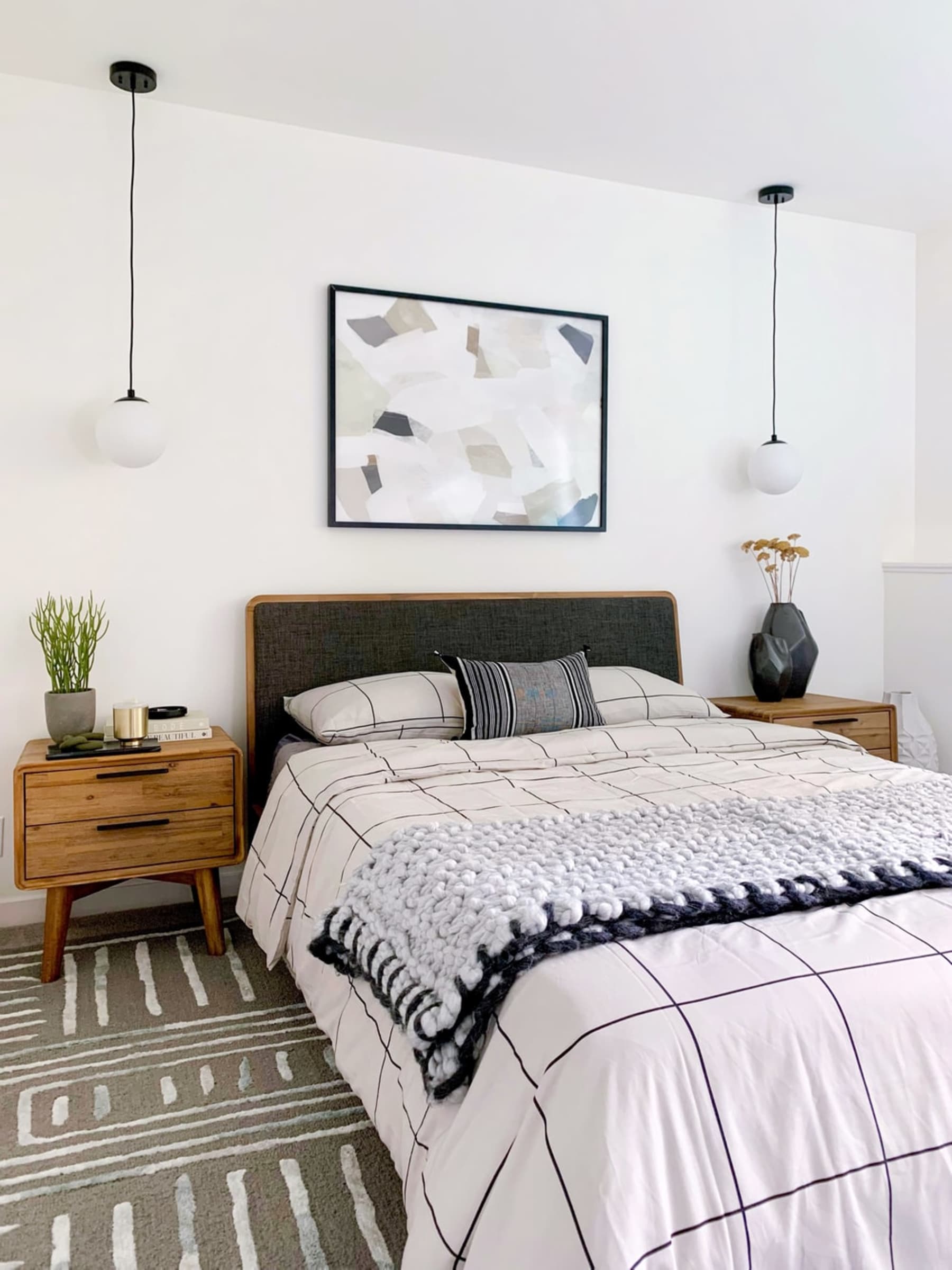 Pendant lights hang from the ceiling on both sides of the bed.