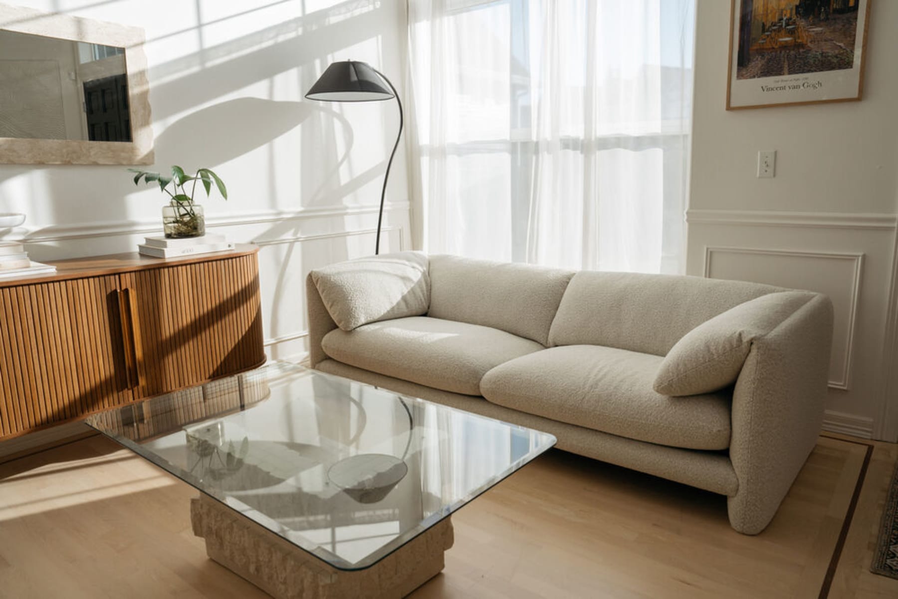 A performance fabric sofa, glass coffee table, and wooden sideboard in a living room.