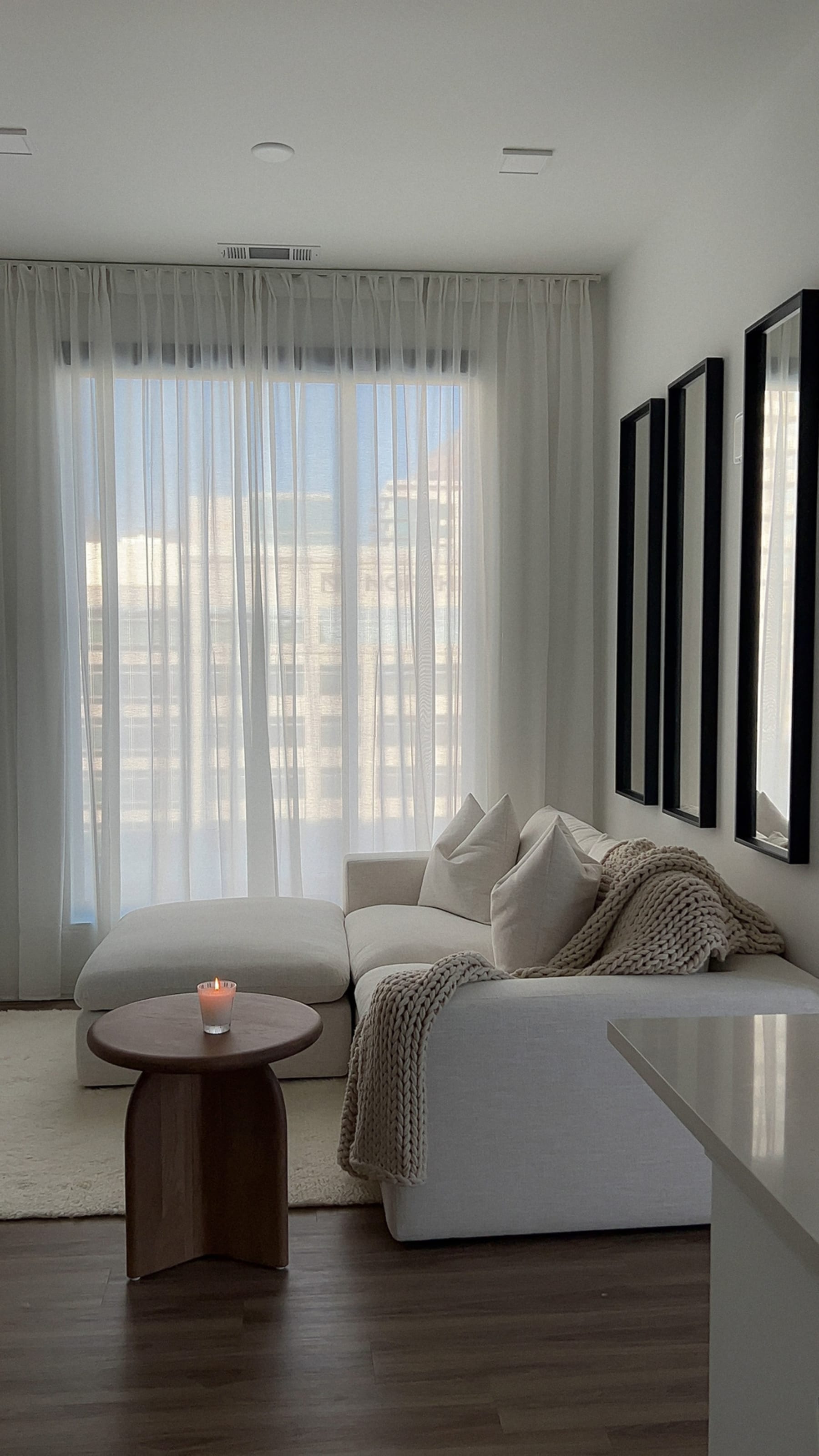 Sheer curtains are used to block out some natural sunlight in the living room