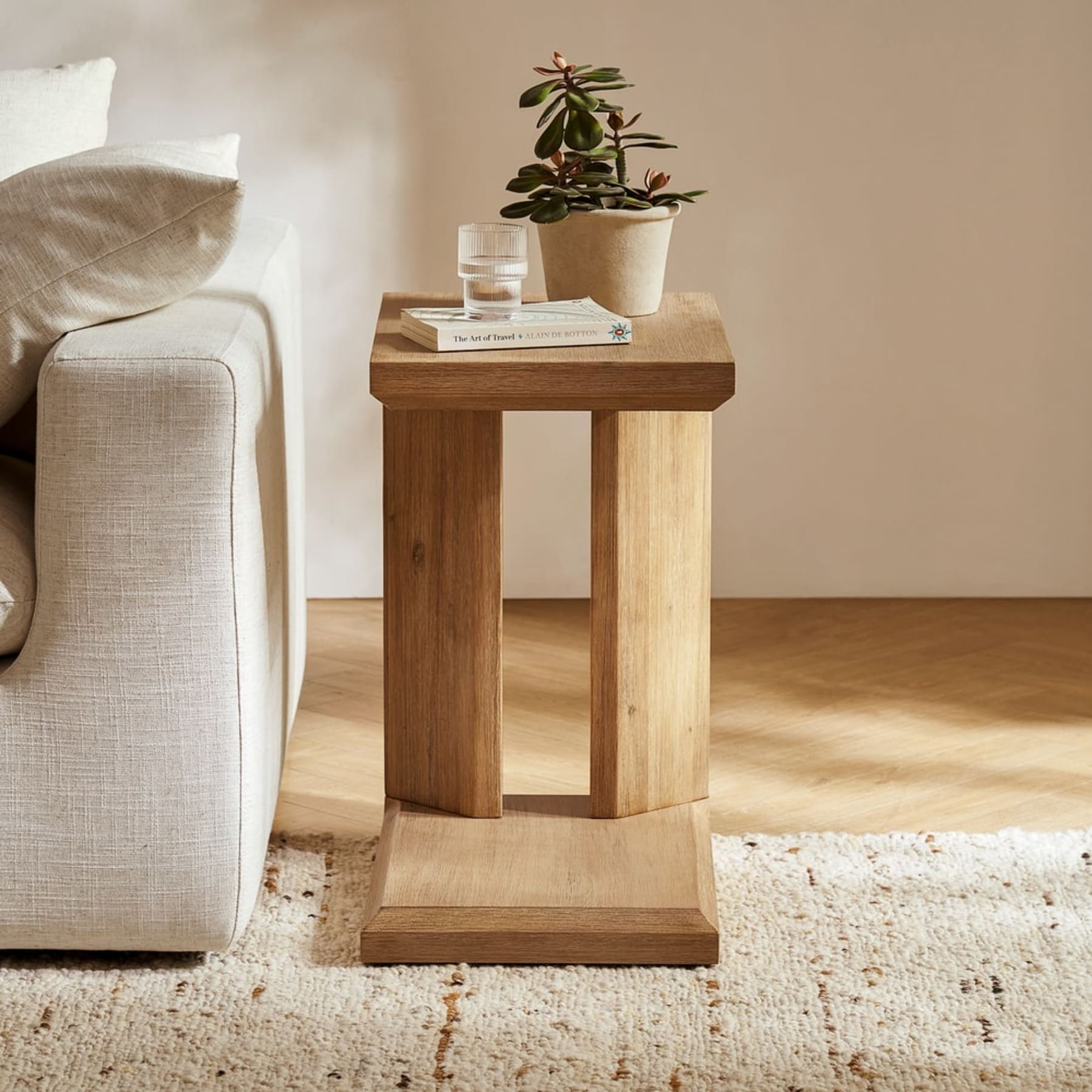 A wooden side table next to a sofa.