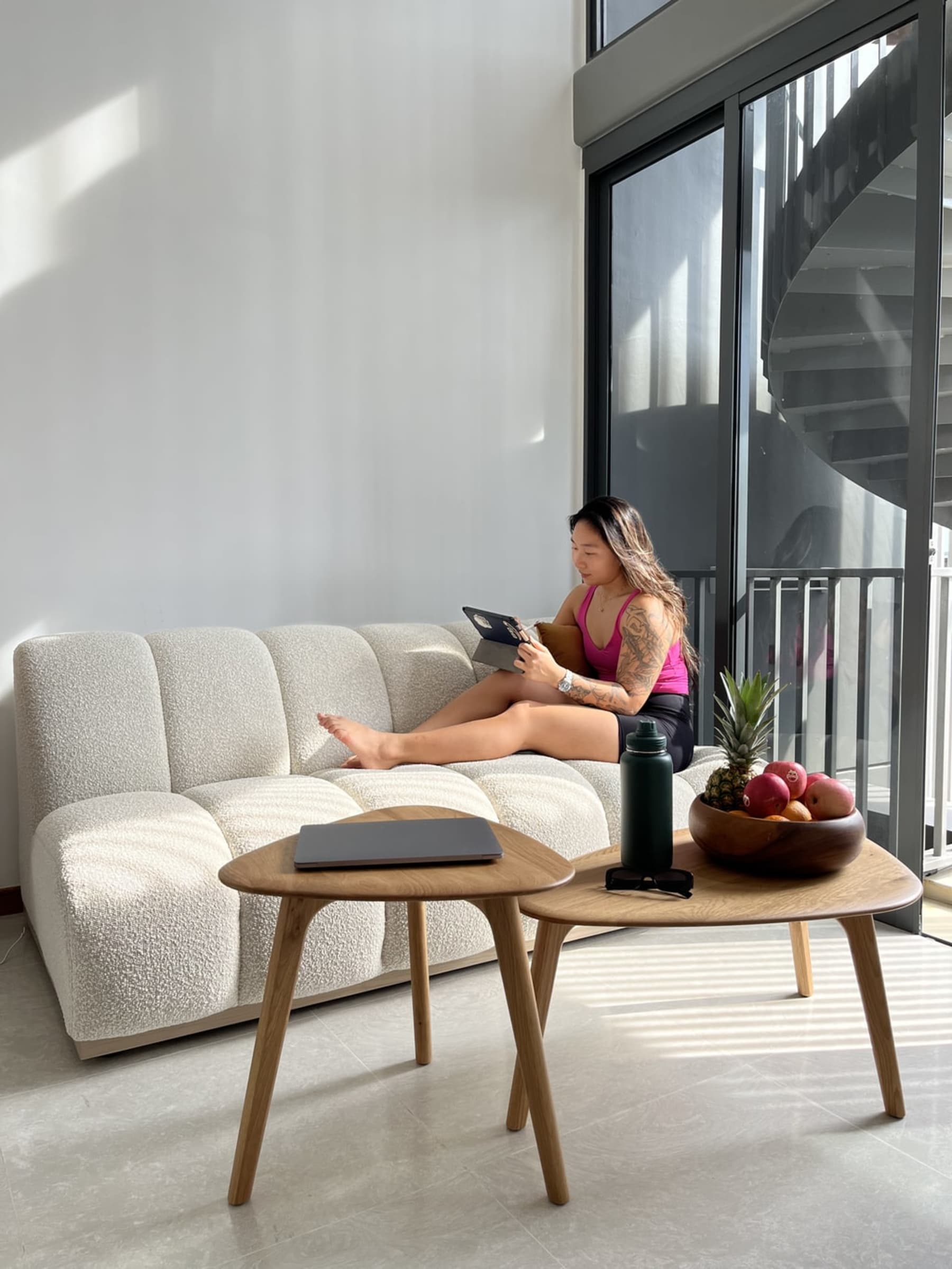 A person is sitting on an armless performance bouclé sofa.