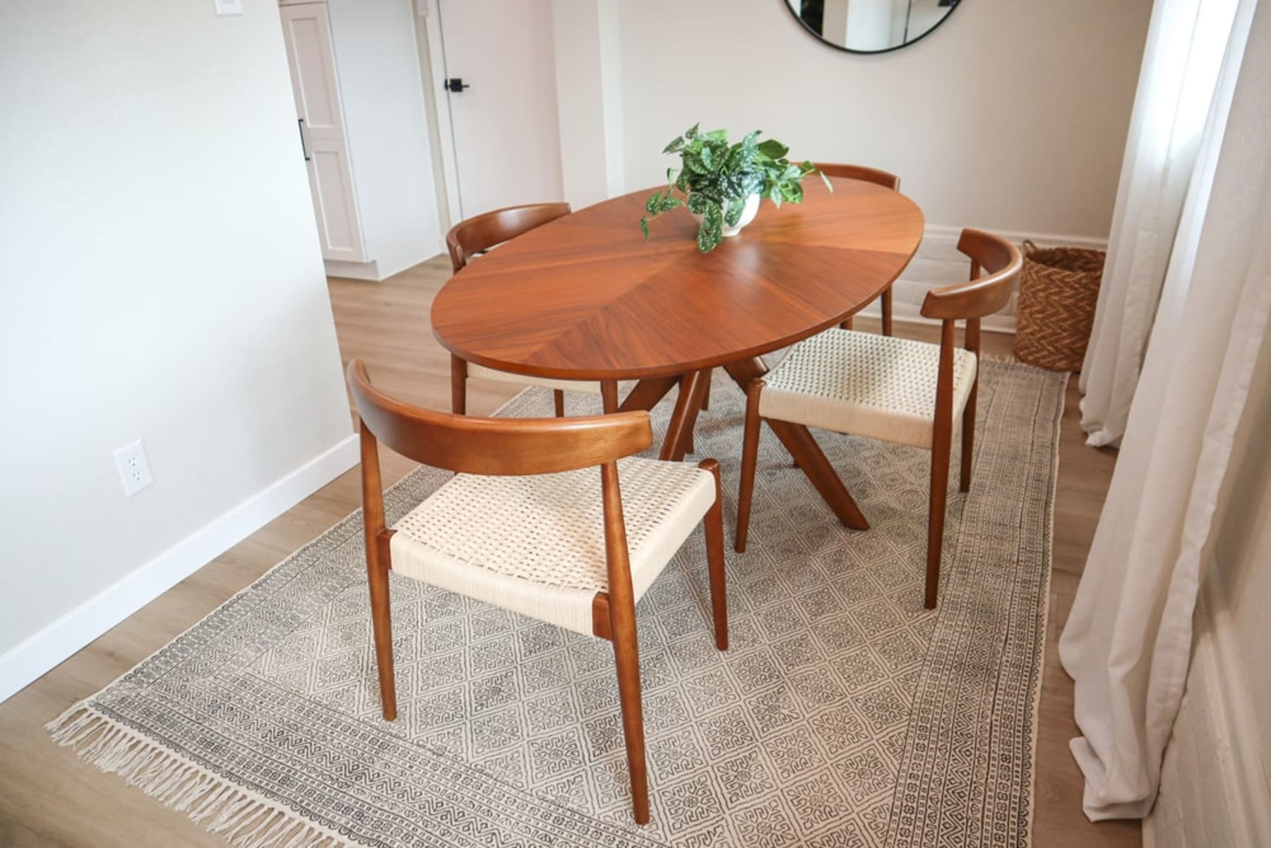 A round dining table with a glass tabletop and matching chairs.