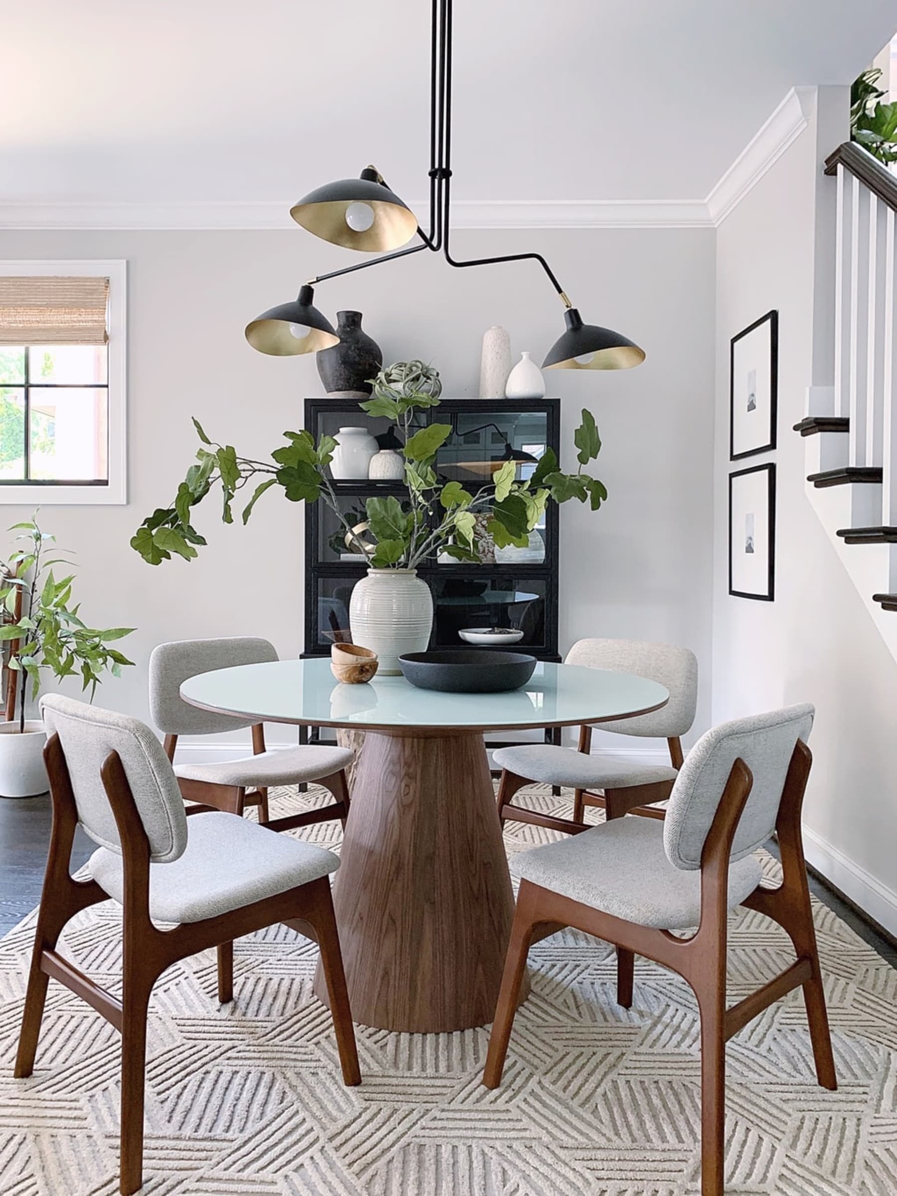 A round dining table with a glass tabletop and matching chairs.