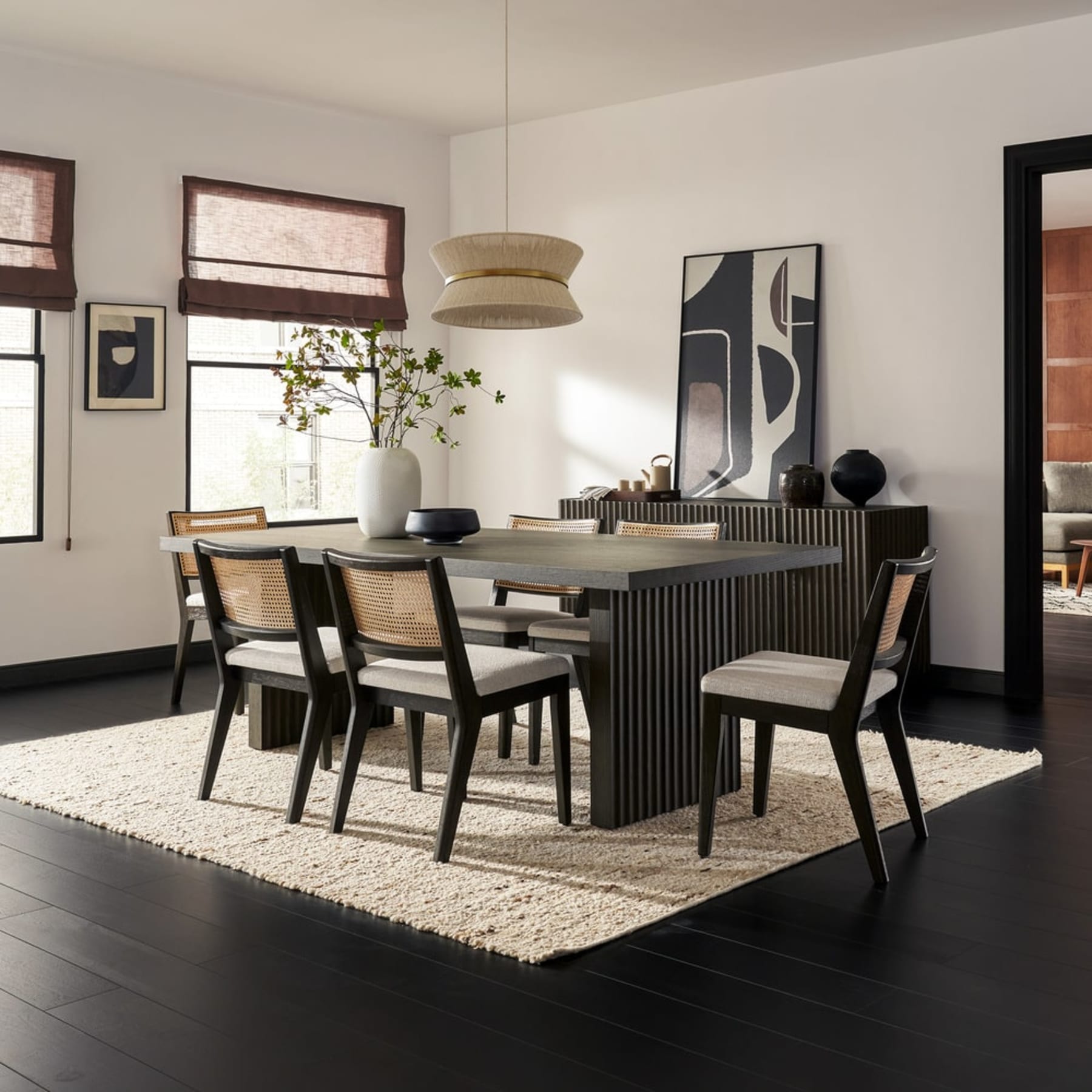 A black wooden dining table with matching chairs.