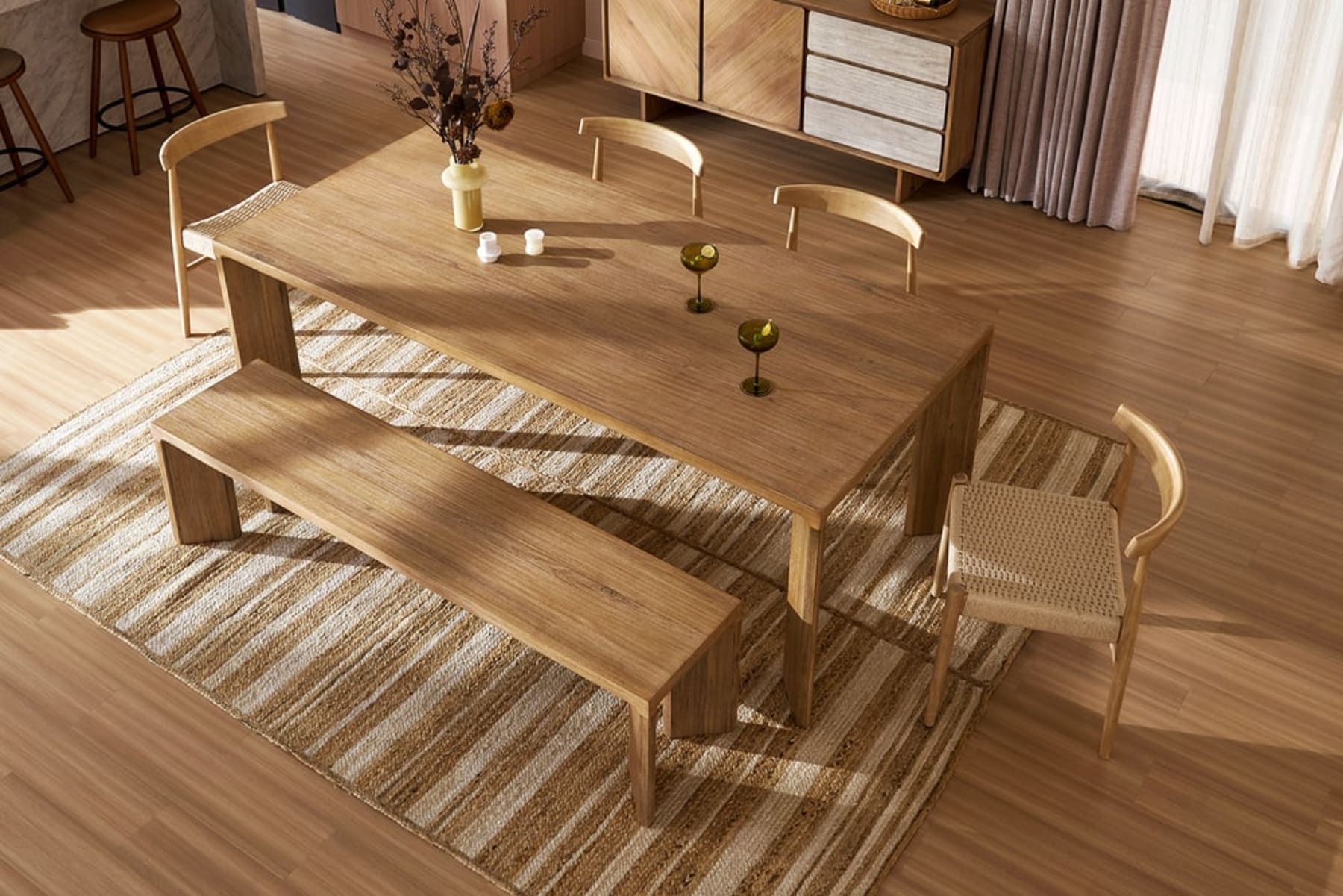 A wooden dining table with a matching bench and 4 chairs.